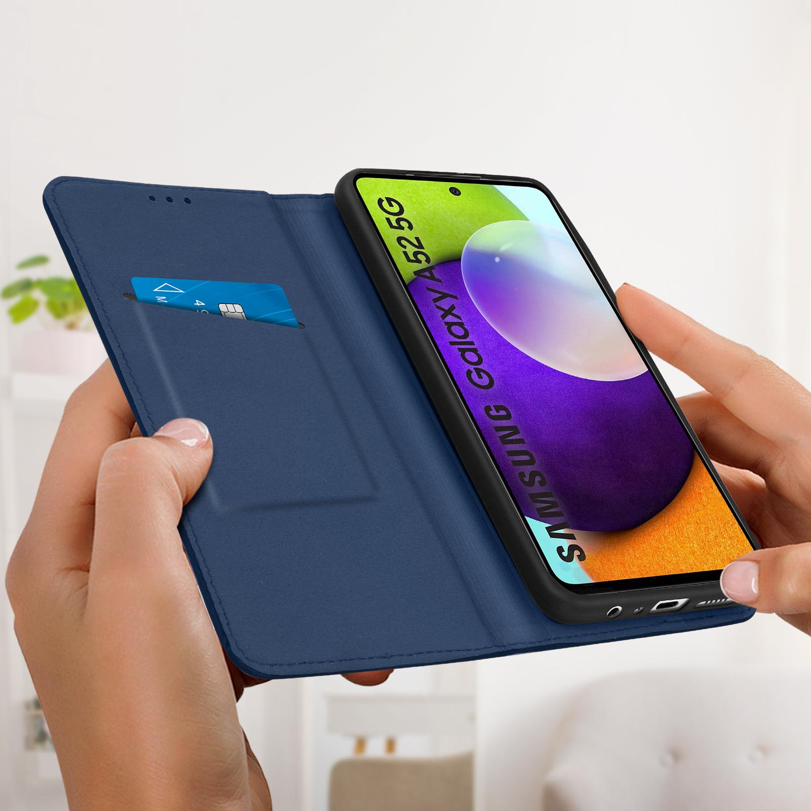 Hände halten eine blaue Handyhülle mit Kreditkarte und Telefon mit Bild.