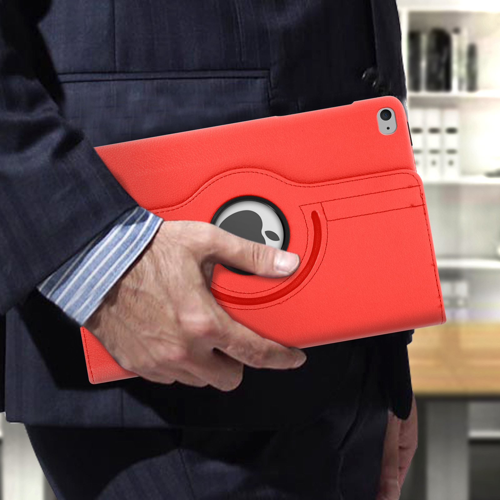 Una persona che tiene una custodia per tablet rossa. La custodia ha un logo Apple nero. Lo sfondo è sfocato.
