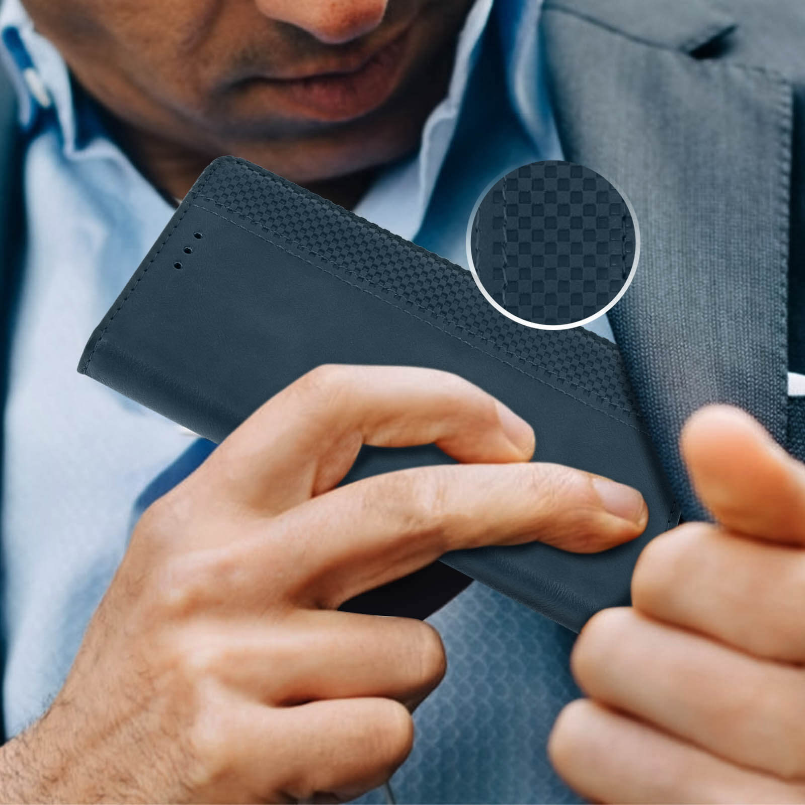Un uomo in giacca e cravatta tiene in mano una custodia per telefono blu scuro. Il dettaglio mostra un motivo strutturato.