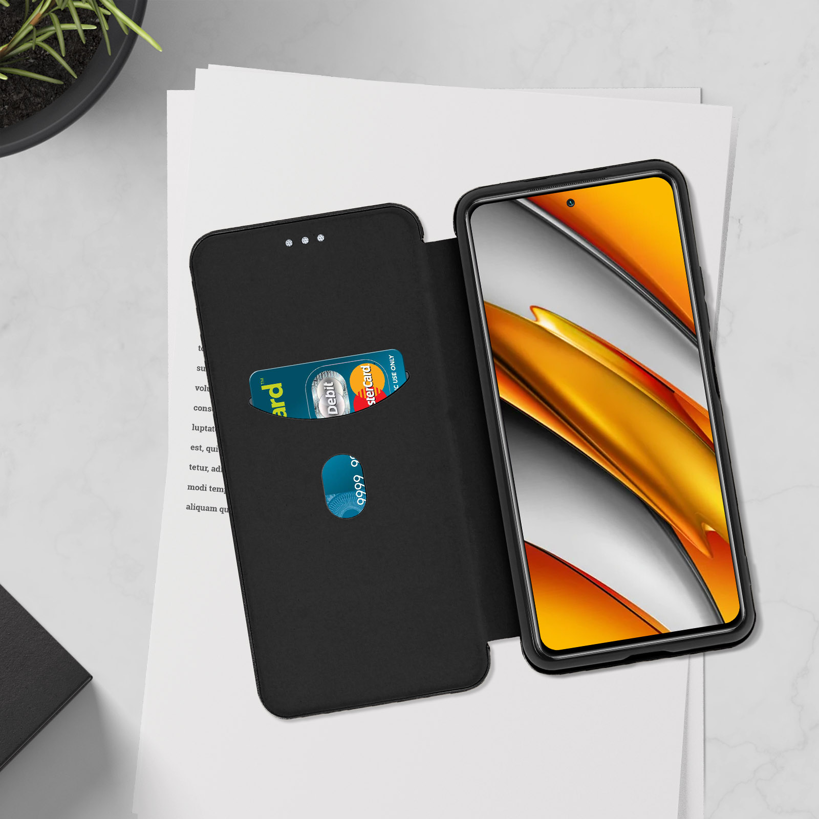 Un telefono nero con retro giallo, in una custodia a portafoglio nera. La custodia ha fessure per carte.