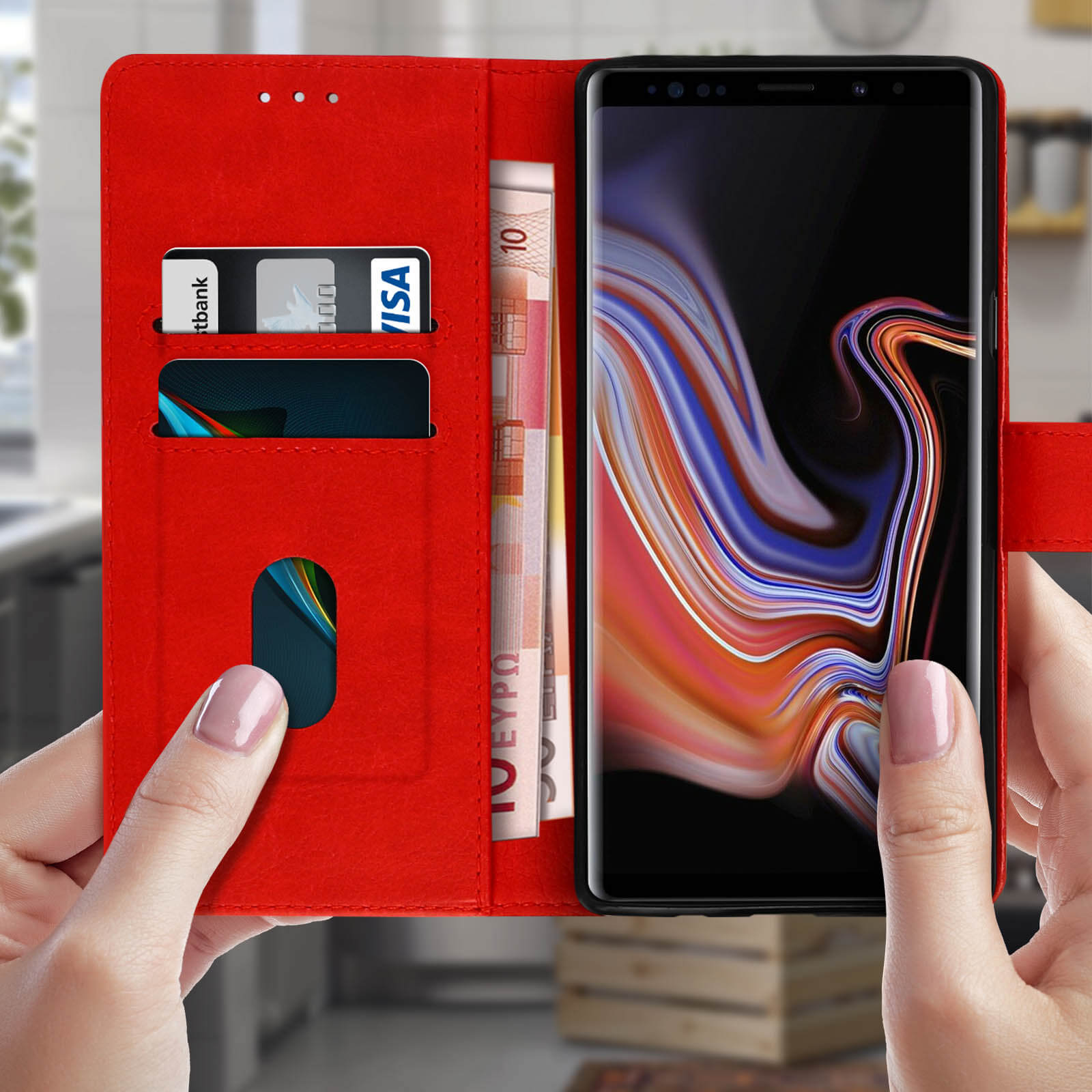 Mani che tengono aperta una custodia rossa per telefono. All'interno carte e denaro, con un telefono.