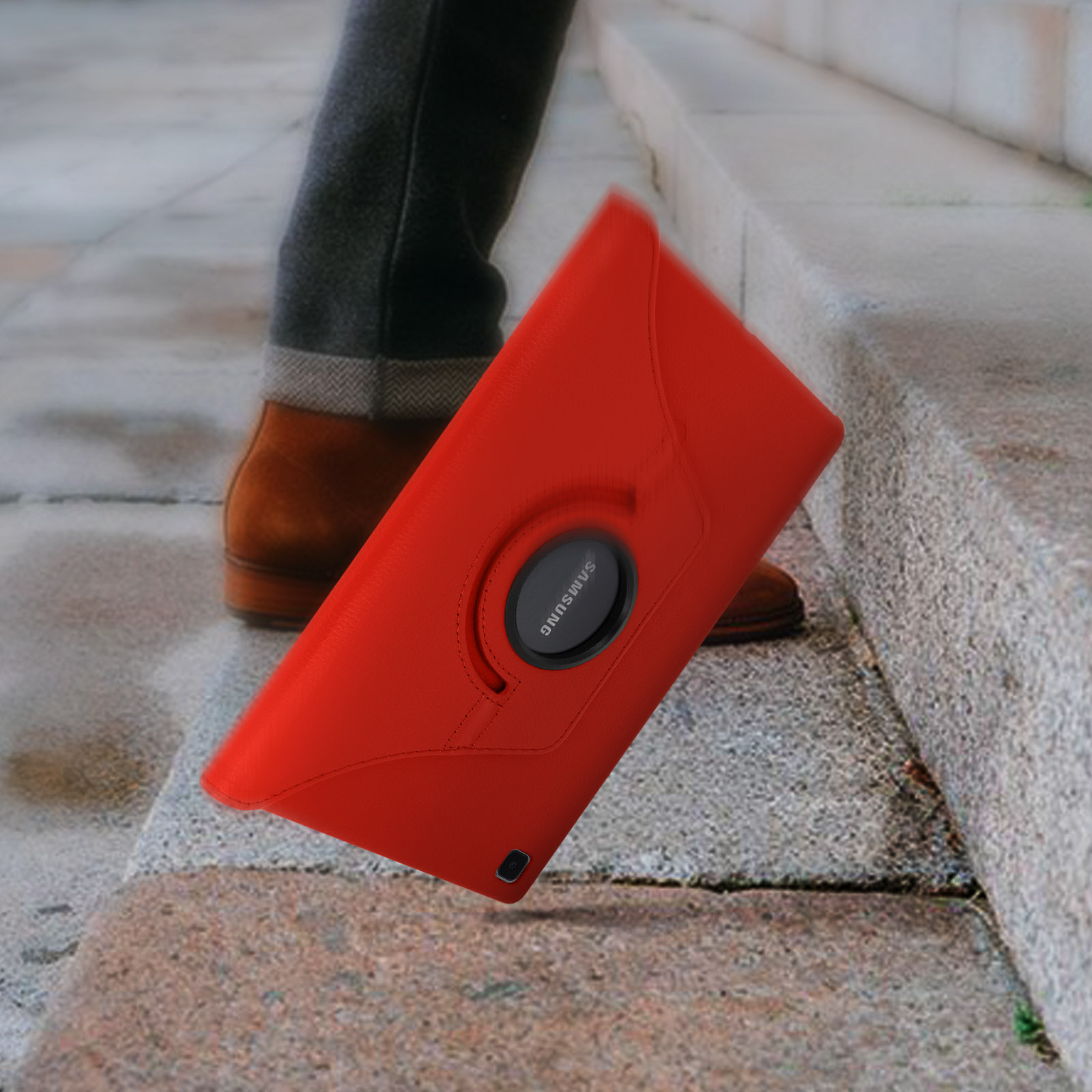 Custodia rossa per tablet che cade, con gambe e scarpe marroni sullo sfondo.