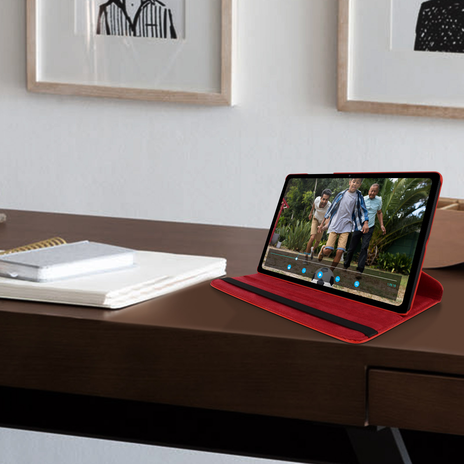 Un tablet riproduce un video su una scrivania, con una cover rossa.