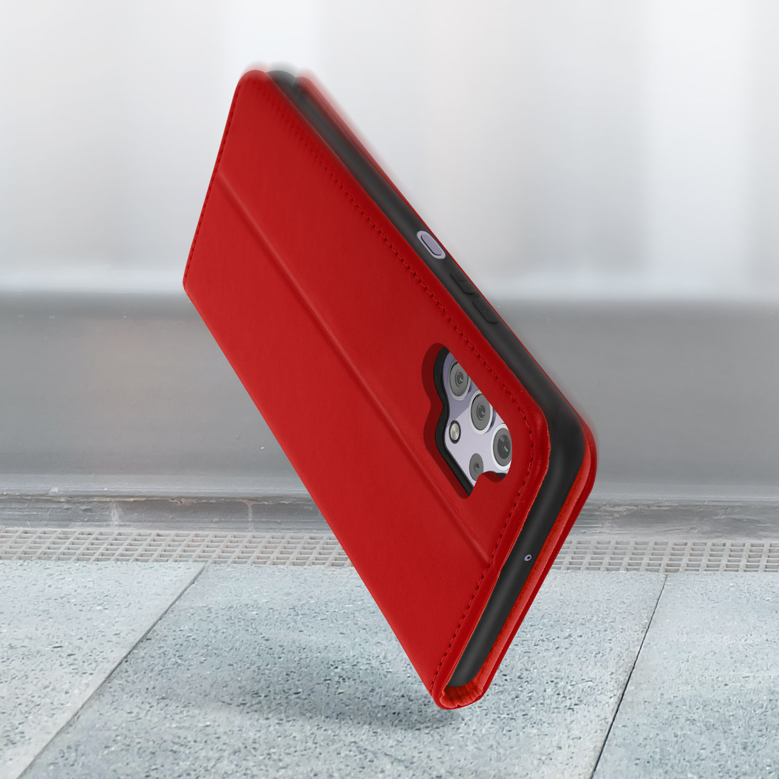 Custodia rossa per telefono che cade su una superficie strutturata, mostrando il design.