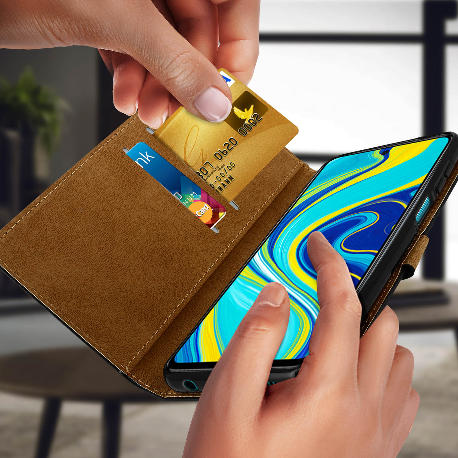 Une main retirant une carte dorée d'un étui de téléphone contenant une autre carte.
