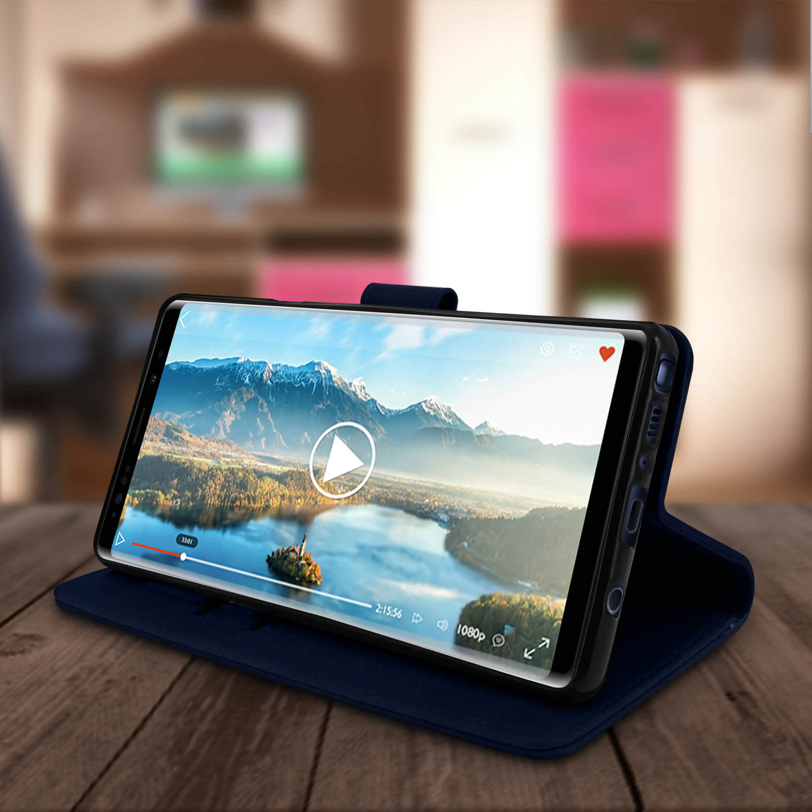 Smartphone in dunkelblauer Hülle, zeigt Video auf einem Holztisch.