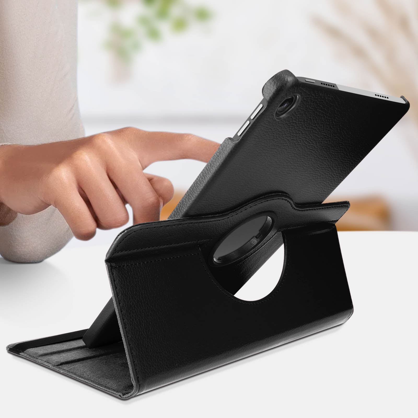 Un tablet nero in una custodia nera, tenuto da una persona.