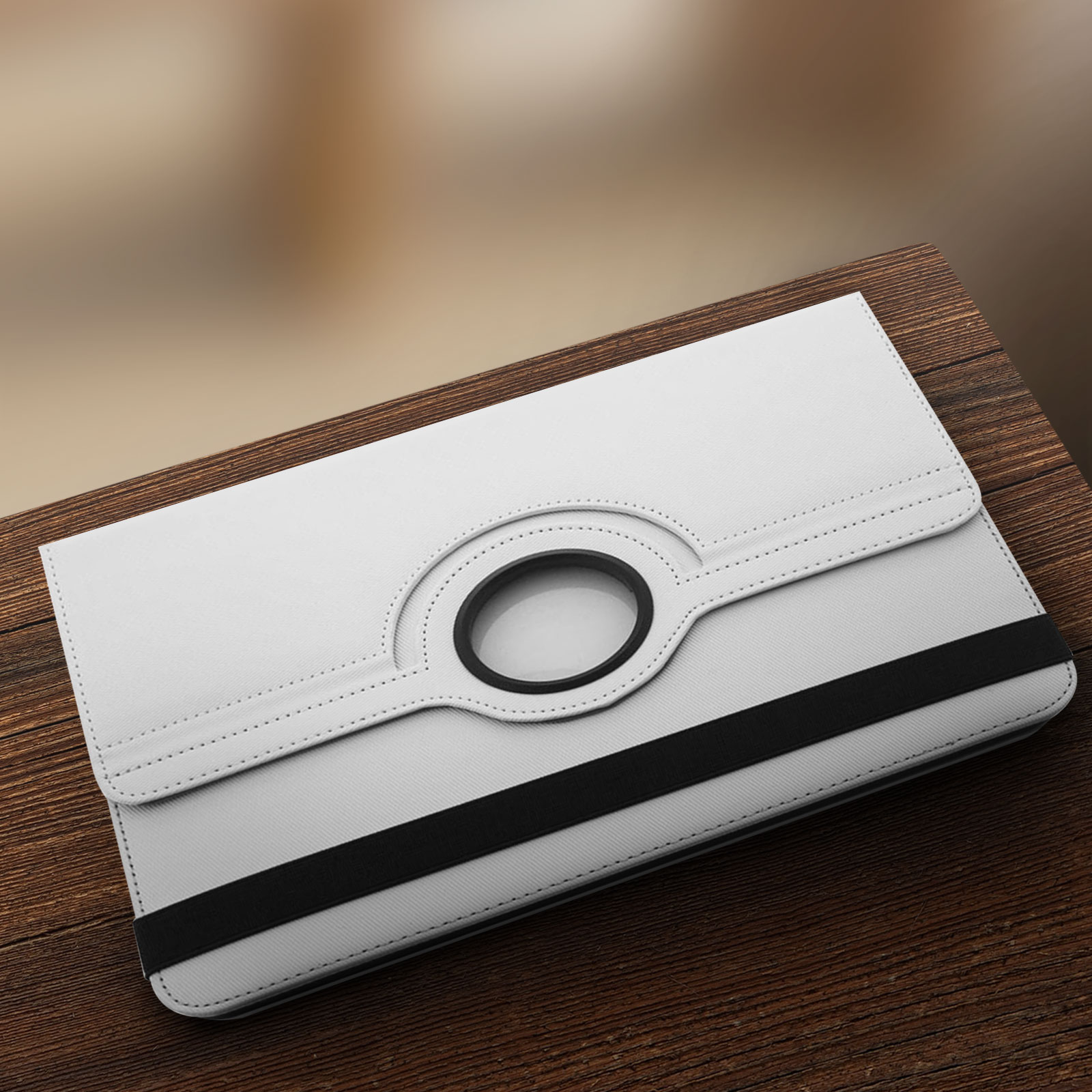 Una custodia bianca per tablet su un tavolo di legno. Una cinghia nera attraversa la custodia.