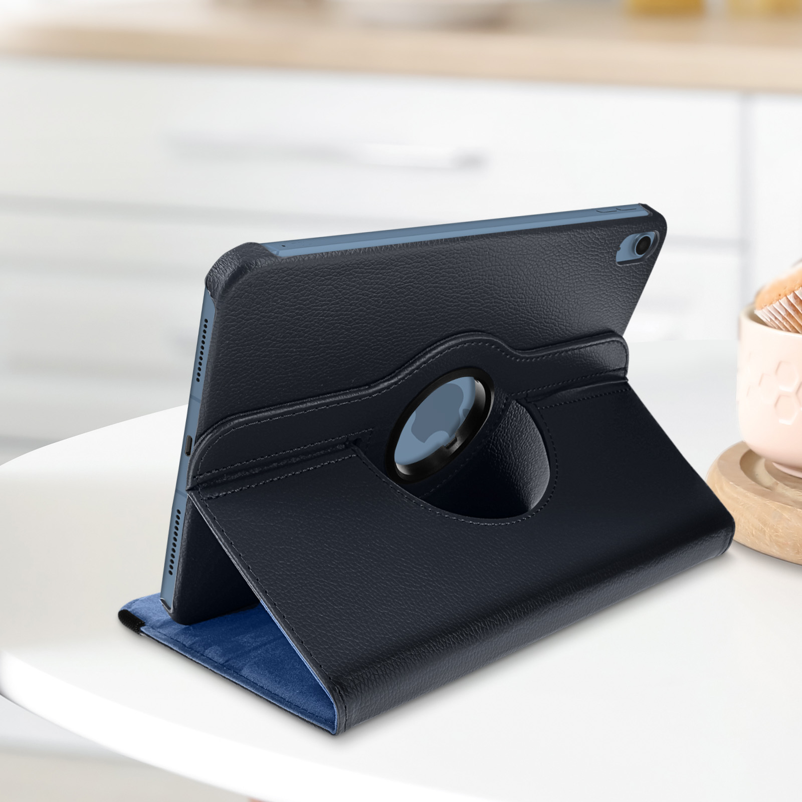 Tablet in custodia blu scuro, su tavolo bianco. Tazza sullo sfondo.