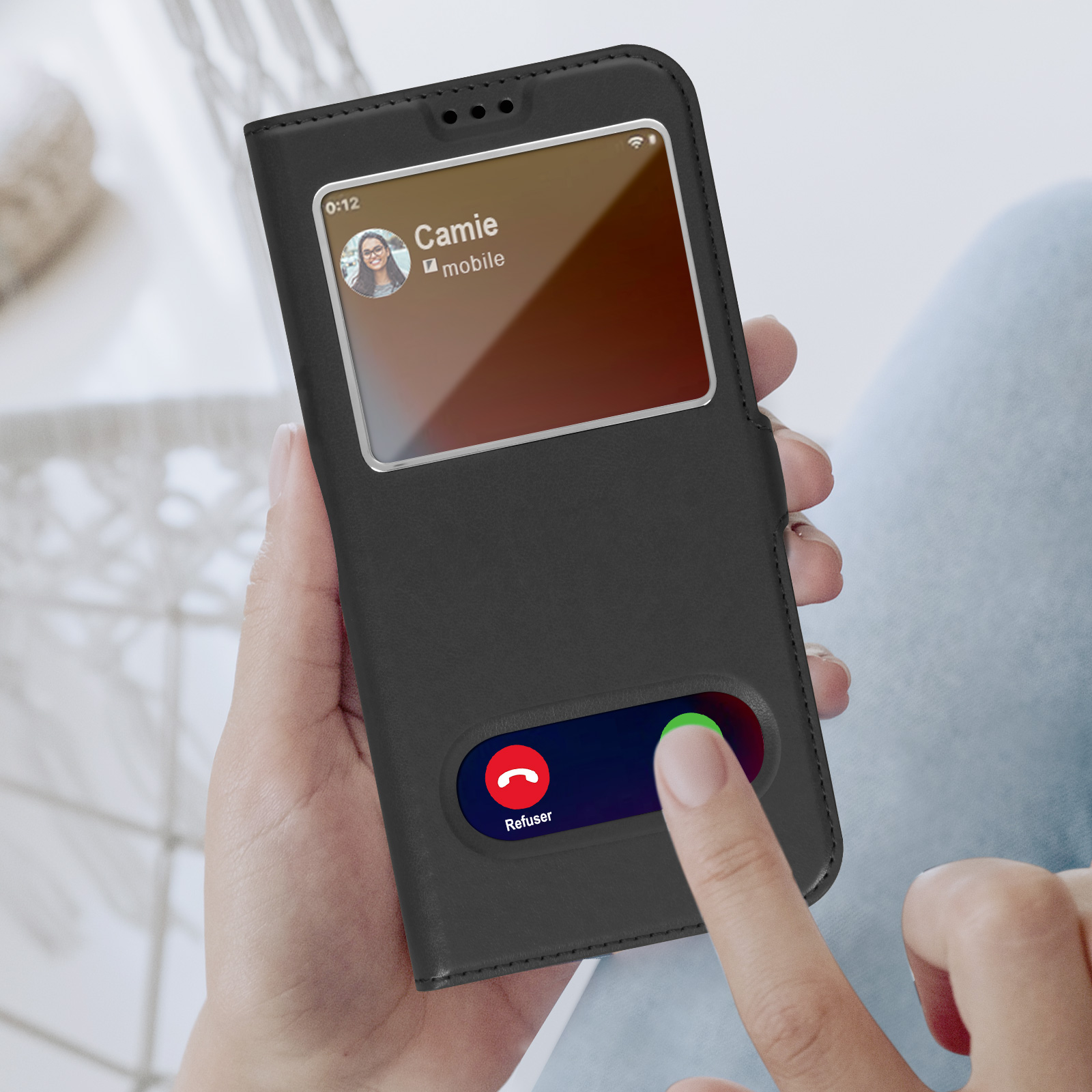 Une main tenant un téléphone dans un étui noir, montrant un appel entrant.
