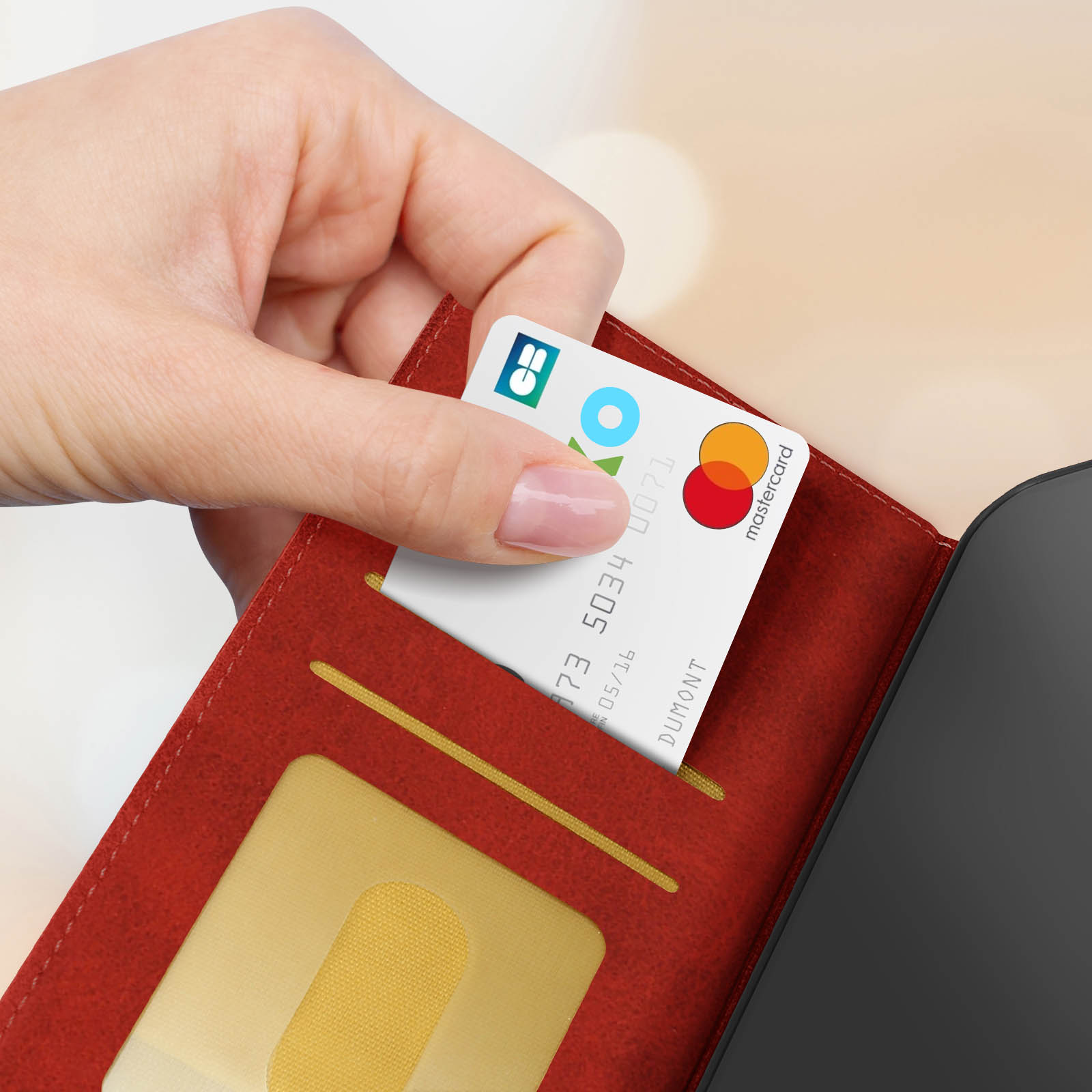 Una mano che tiene una carta di credito da un portafoglio rosso, con il logo Mastercard.