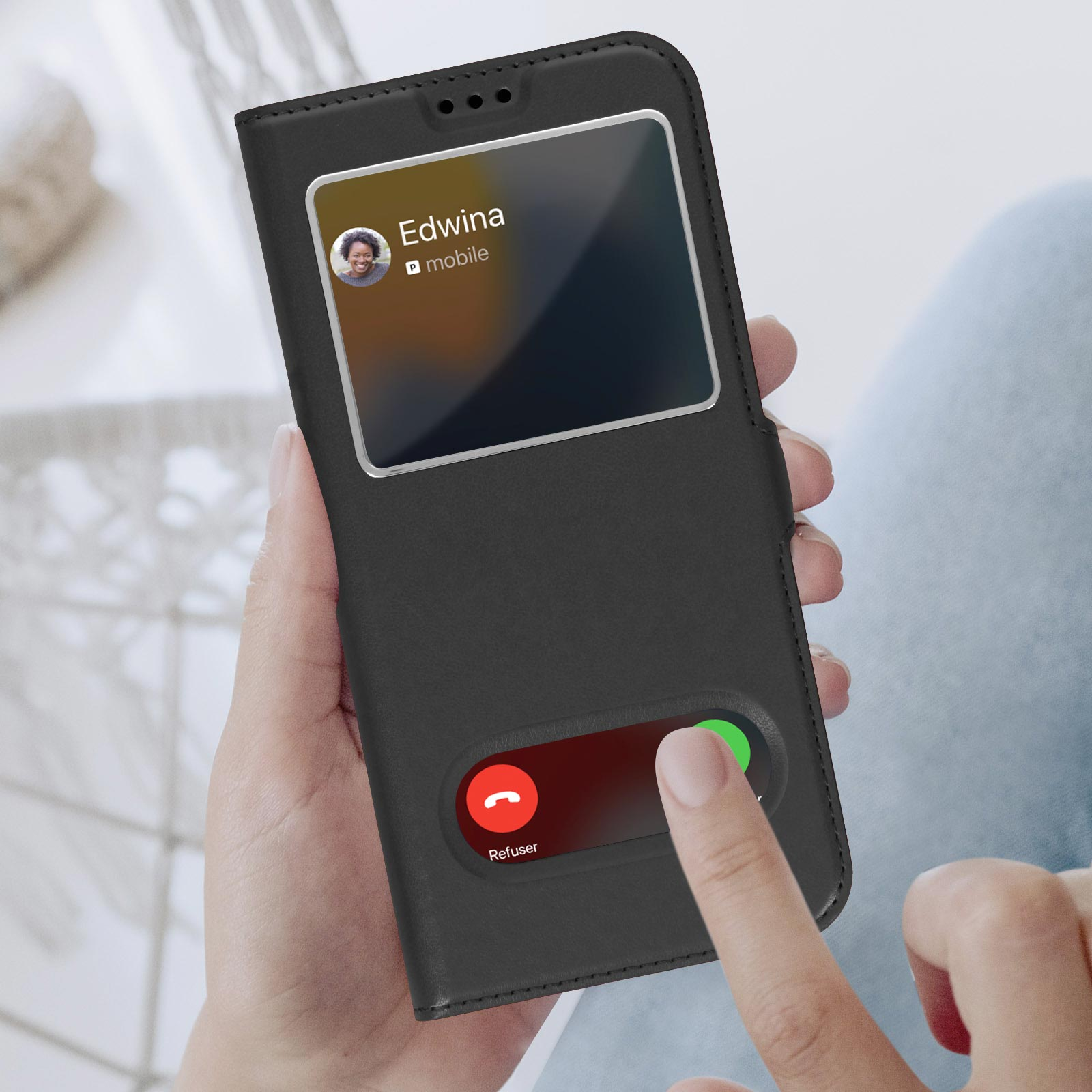 Une main tient un étui de téléphone noir avec un écran d'appel entrant. L'écran affiche l'image d'une personne.