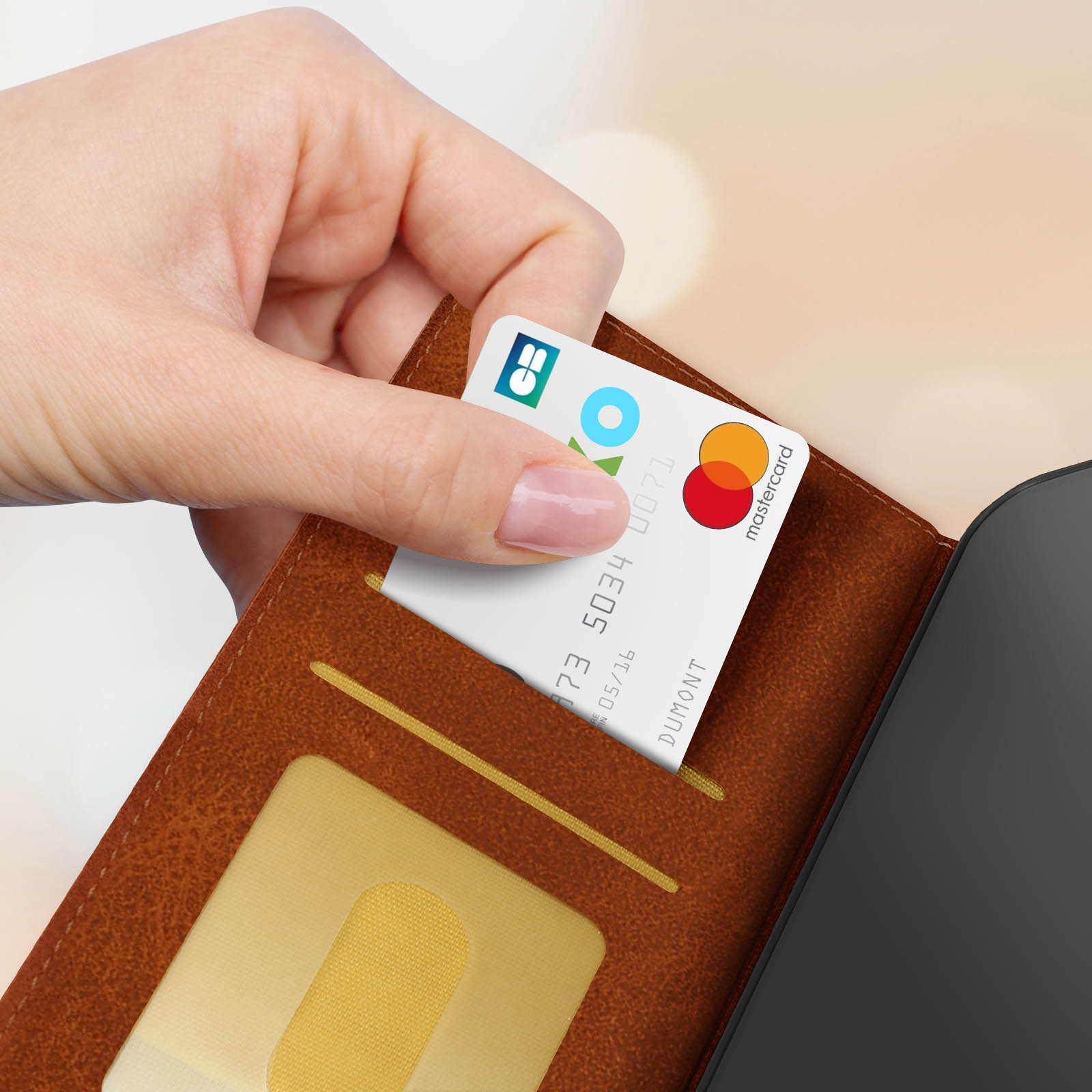 Una mano inserisce una carta di credito con il logo Mastercard in un portafoglio marrone. Il portafoglio è aperto.