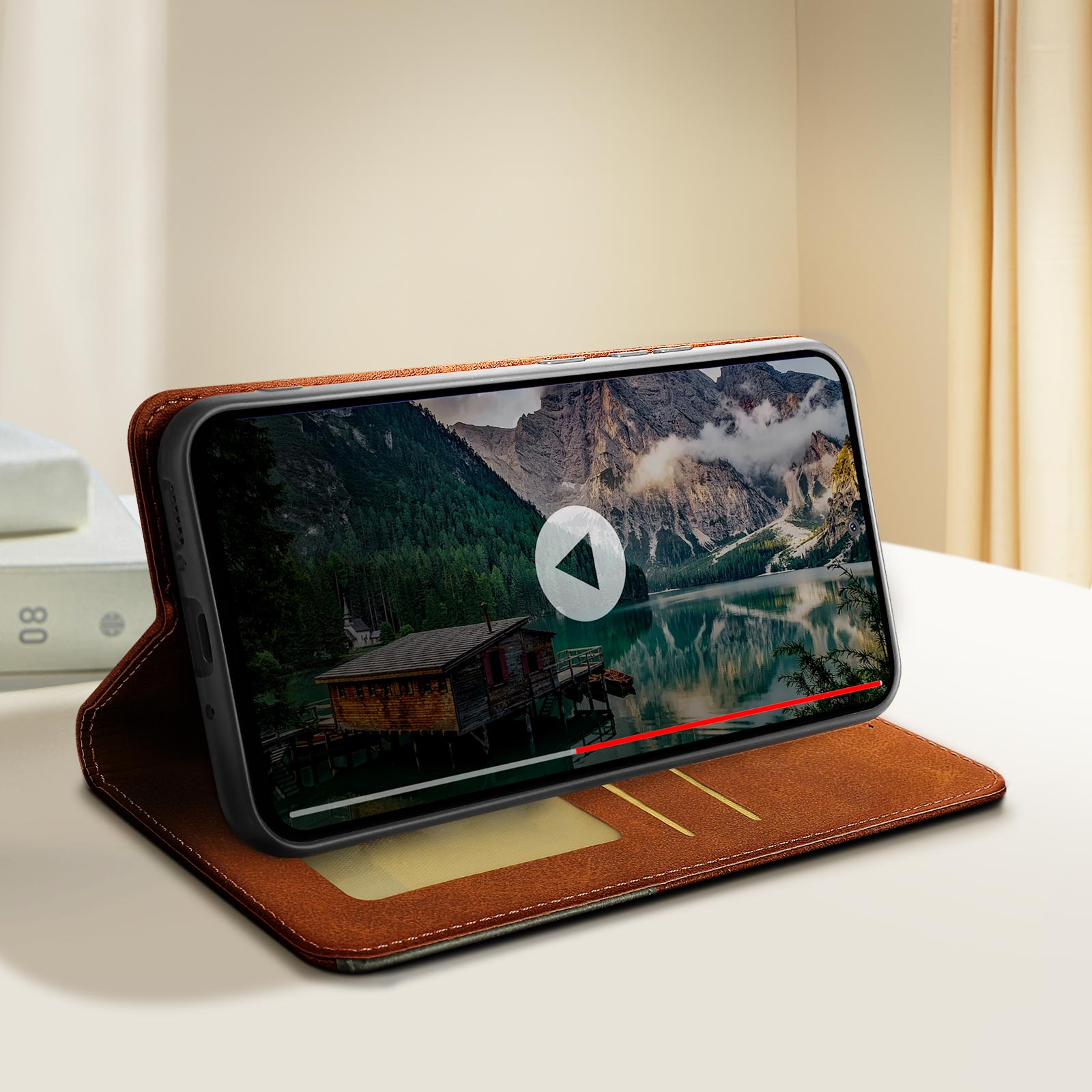Telefono in custodia a portafoglio che riproduce un video. Lo sfondo è una montagna e un lago.