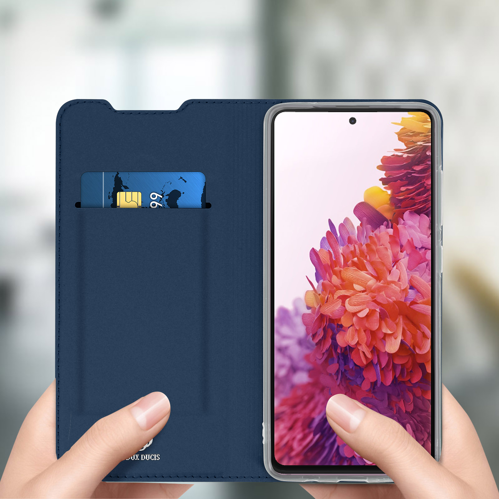 Handen die een blauwe telefoonhoes vasthouden met een creditcardvak, een telefoon tonen.