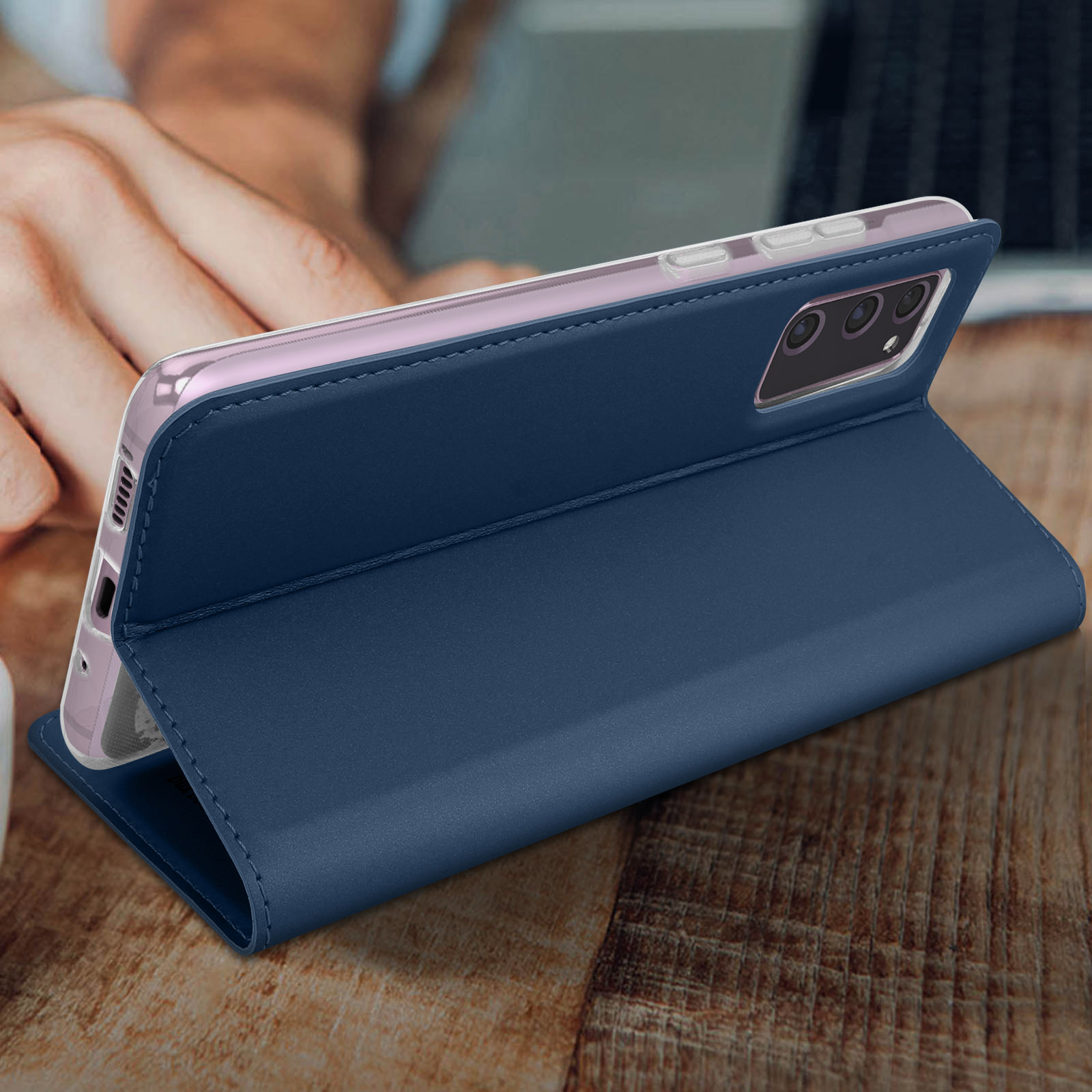 Marineblauwe telefoonhoes met telefoon erin, op een houten oppervlak.