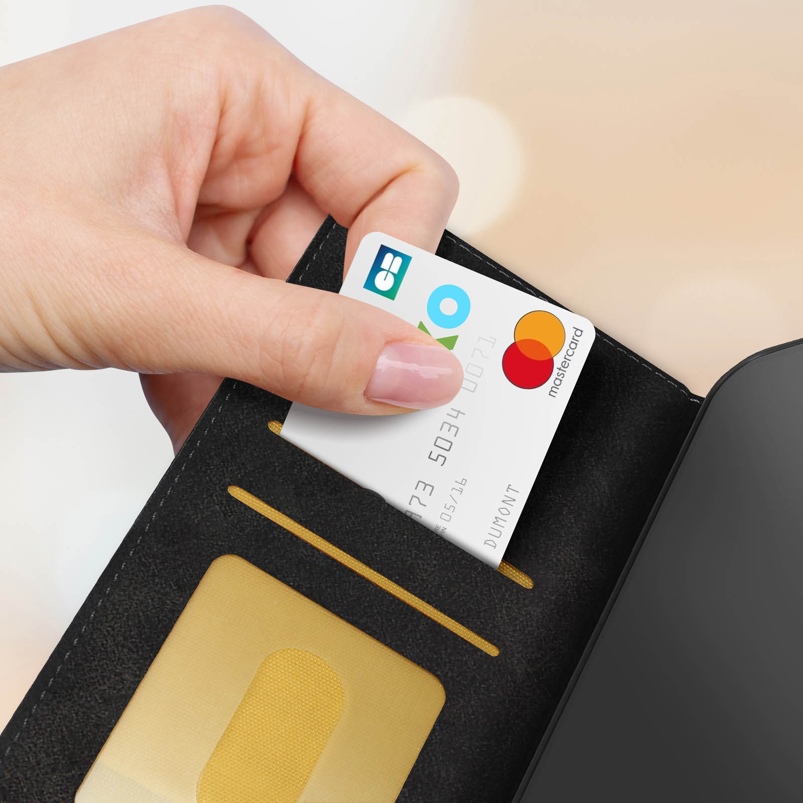 Mano che inserisce una carta di credito in un portafoglio nero.