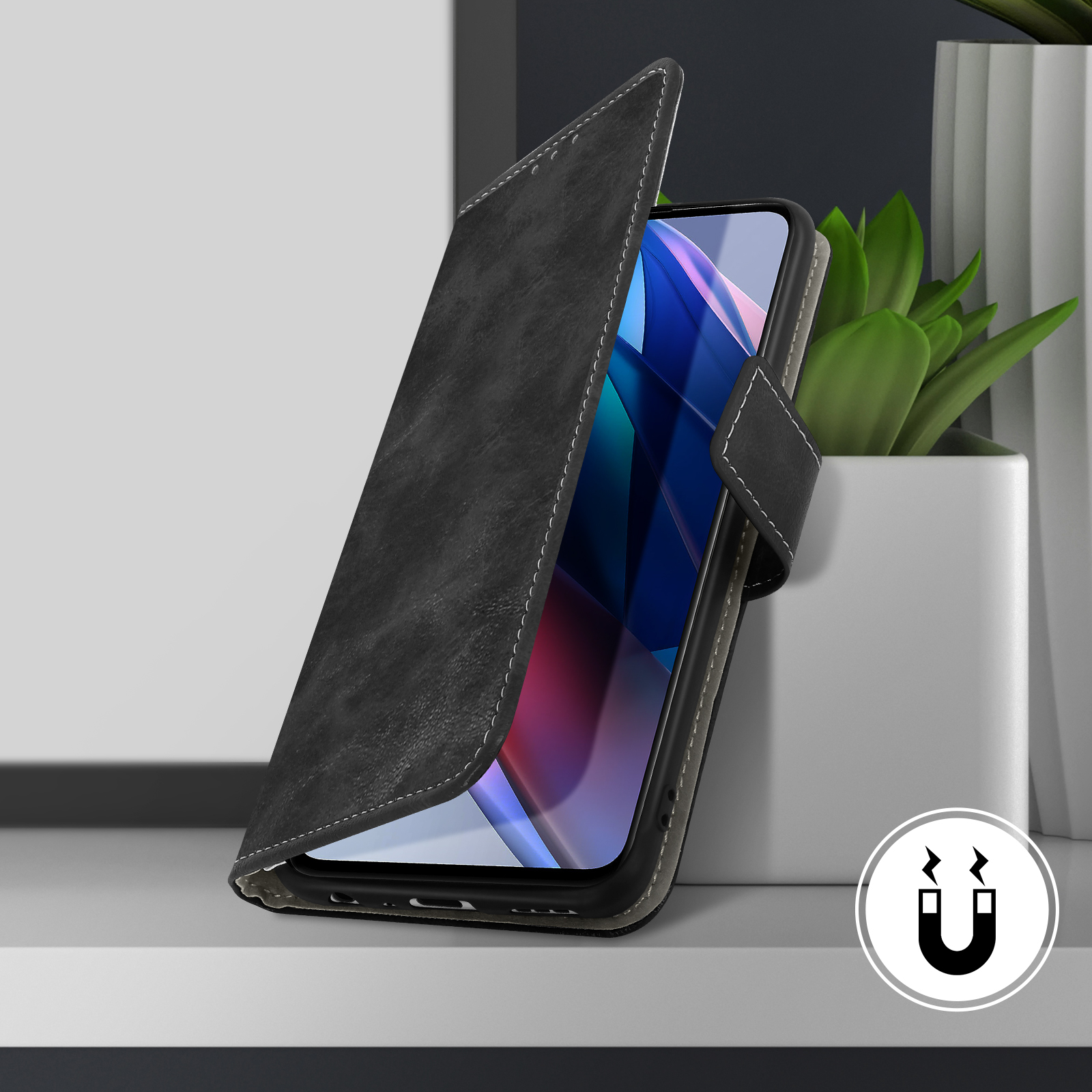 Coque de téléphone noire avec symbole de fermeture magnétique. Le téléphone est à l'intérieur, près d'une plante.