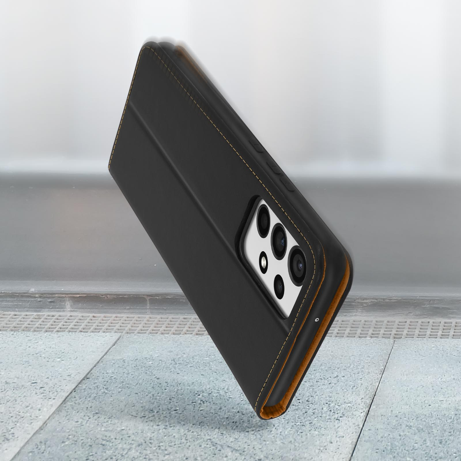 Schwarze Leder-Handyhülle in Bewegung. Telefon mit mehreren Kameras. Gelbe Nähte sichtbar.