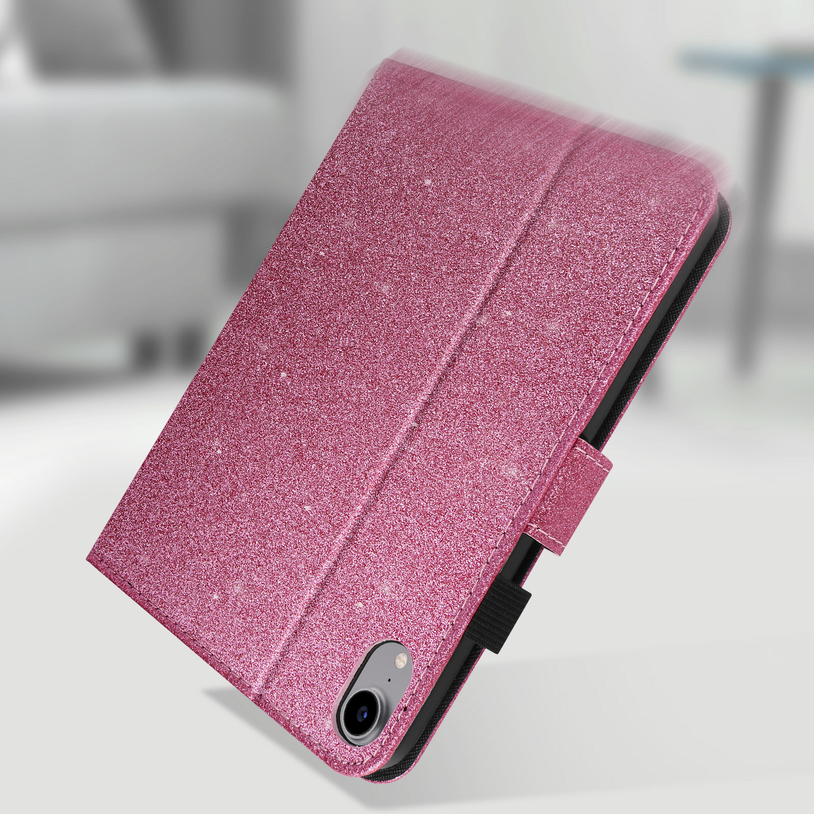 Custodia per tablet rosa glitterata angolata. Cinturino e chiusura neri. Sfondo bianco con ombra sfocata.