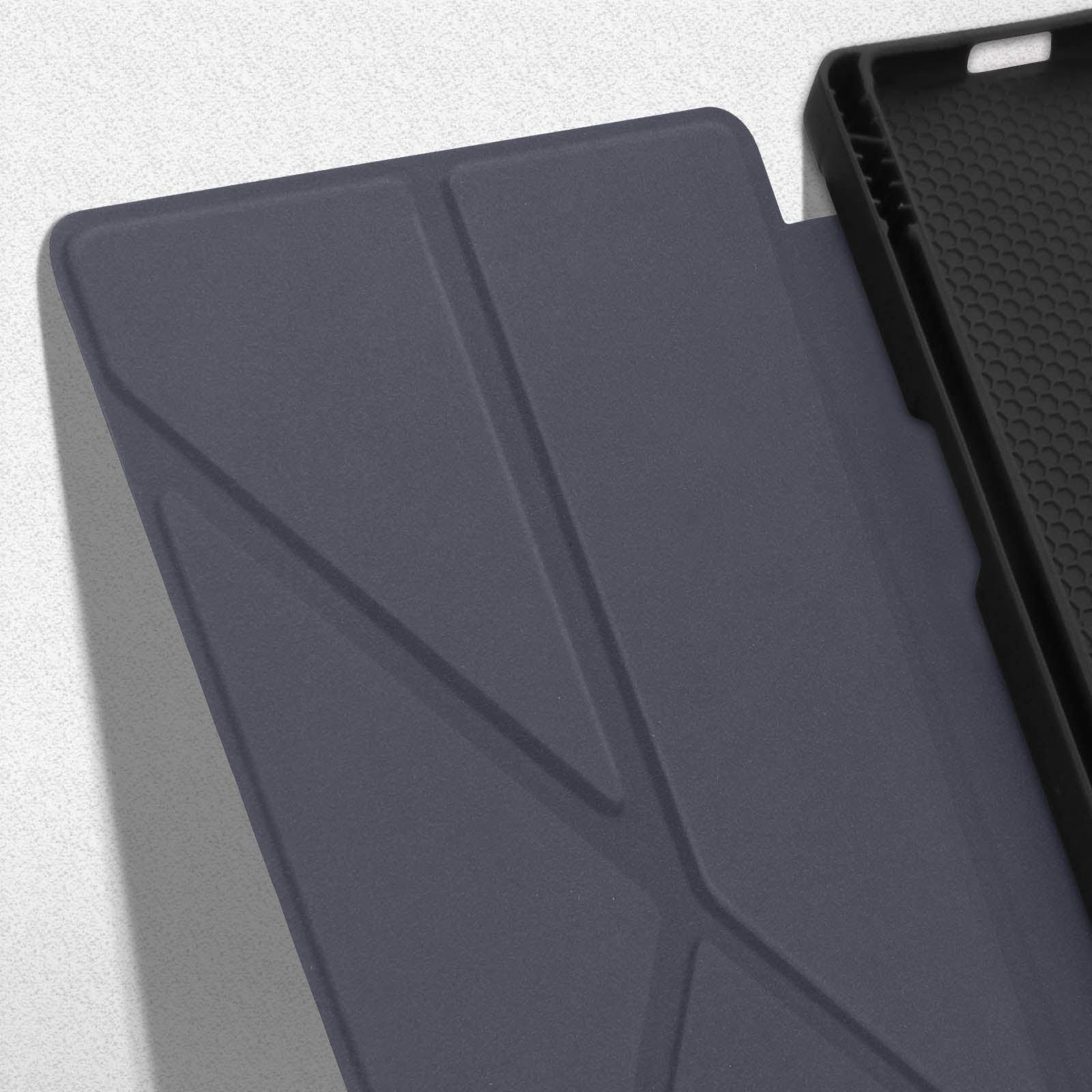Primo piano di una custodia blu scuro per telefono con un design geometrico, parzialmente aperta.
