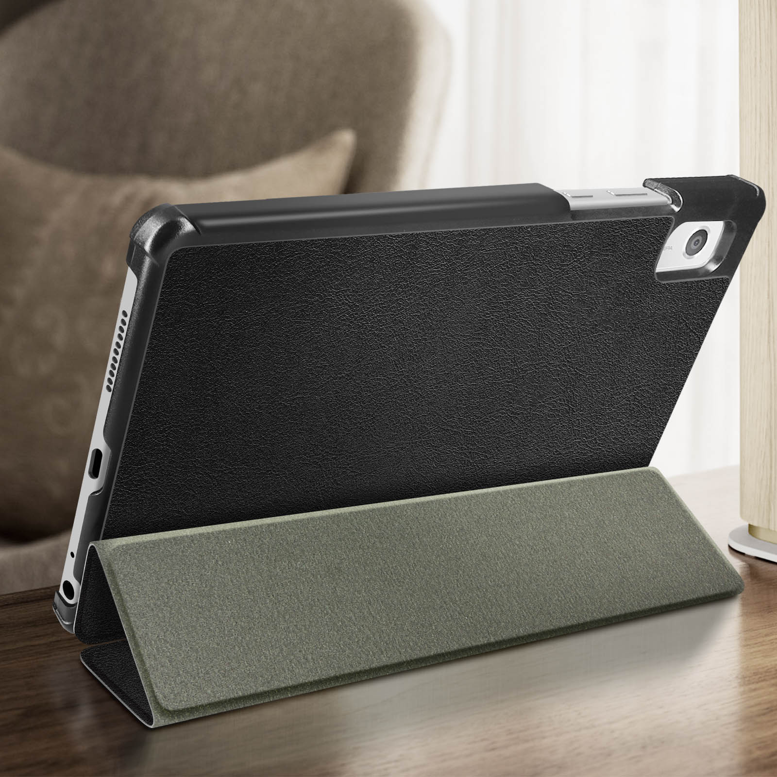 Un tablet in una custodia nera e verde è su un tavolo di legno.