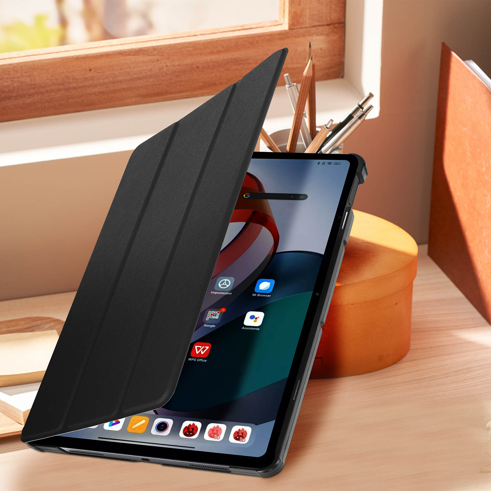 Tablet in custodia nera, aperto, che mostra schermo con app, su scrivania in legno.