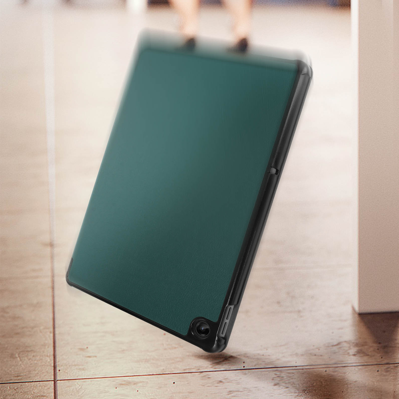 Una custodia per tablet verde su un pavimento. La fotocamera e il bordo del tablet sono visibili.
