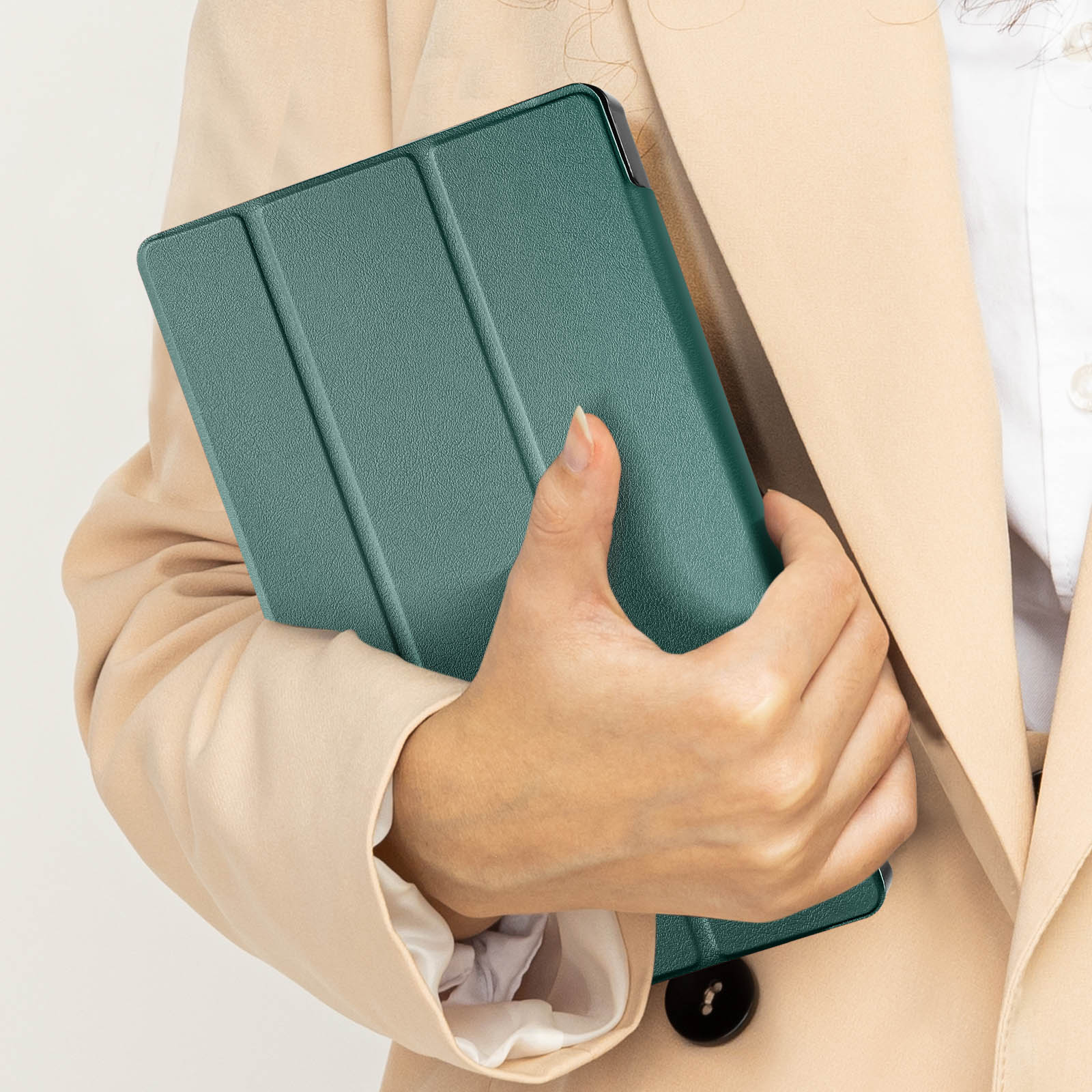 Una mano tiene una custodia verde per tablet. La custodia è chiusa e ha tre pieghe. Lo sfondo è beige.