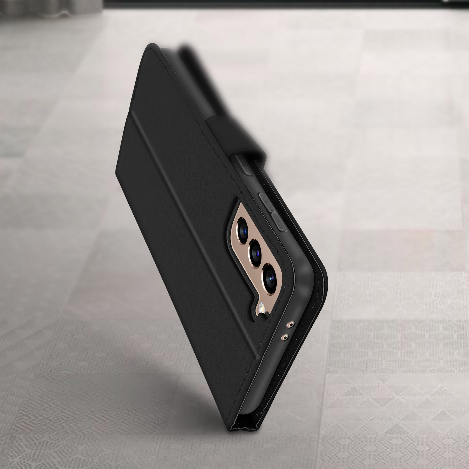Un telefono nero in una custodia nera è mostrato. Il telefono è angolato a sinistra su una superficie.