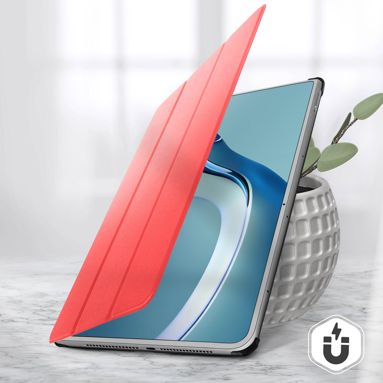 Una custodia rossa per tablet è aperta, rivelando lo schermo. Una pianta è in un vaso bianco.