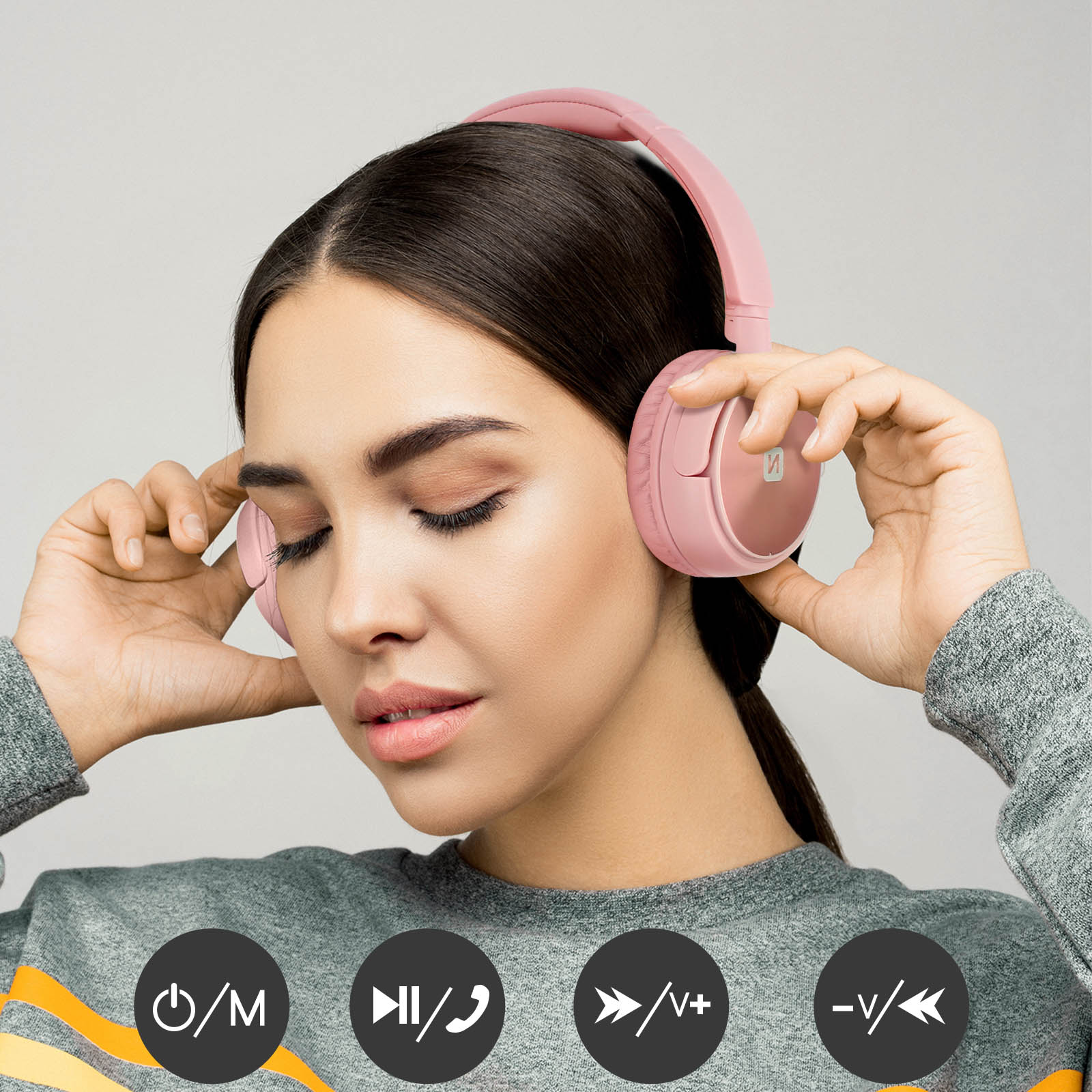 Vrouw met roze koptelefoon. Bedieningsknoppen aan de onderkant zijn zichtbaar.