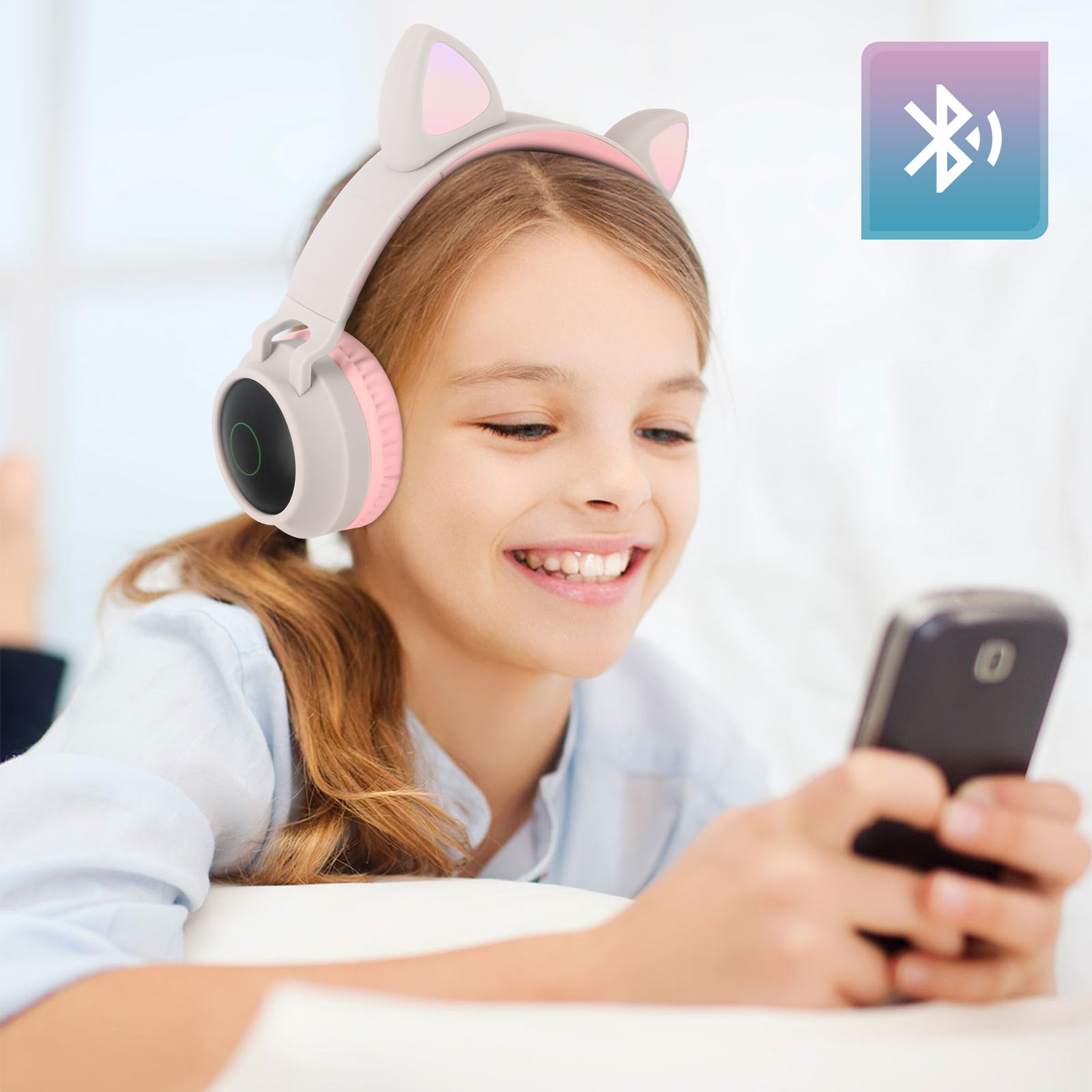 Ein Mädchen mit Katzenohrkopfhörern, das ein Telefon hält, Bluetooth-Symbol angezeigt.