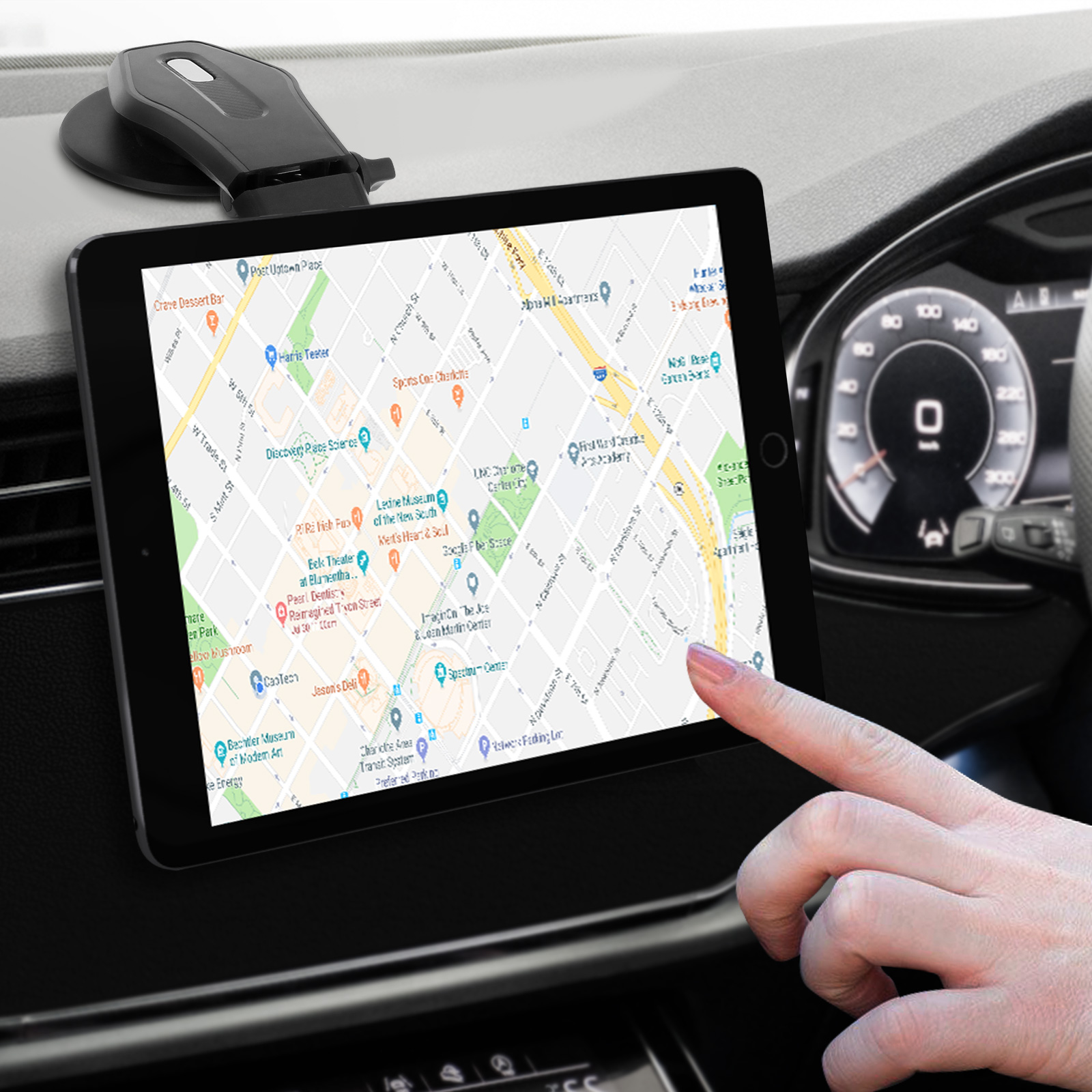 Tablet in einer Autohalterung. Finger auf dem Bildschirm. Fahrzeuginnenraum sichtbar. Karte.