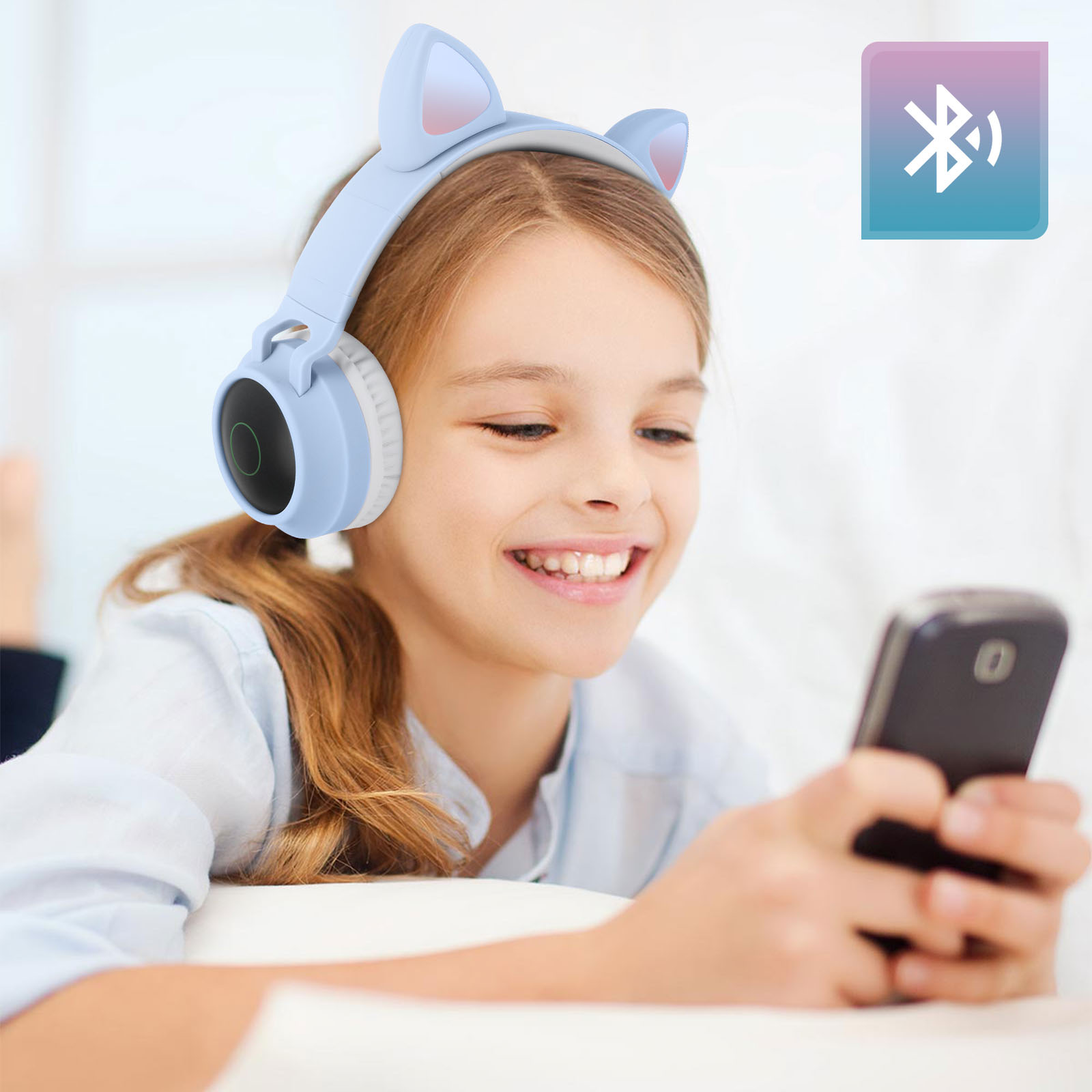 Ein Mädchen mit Katzenohr-Kopfhörern, das ein Telefon benutzt.