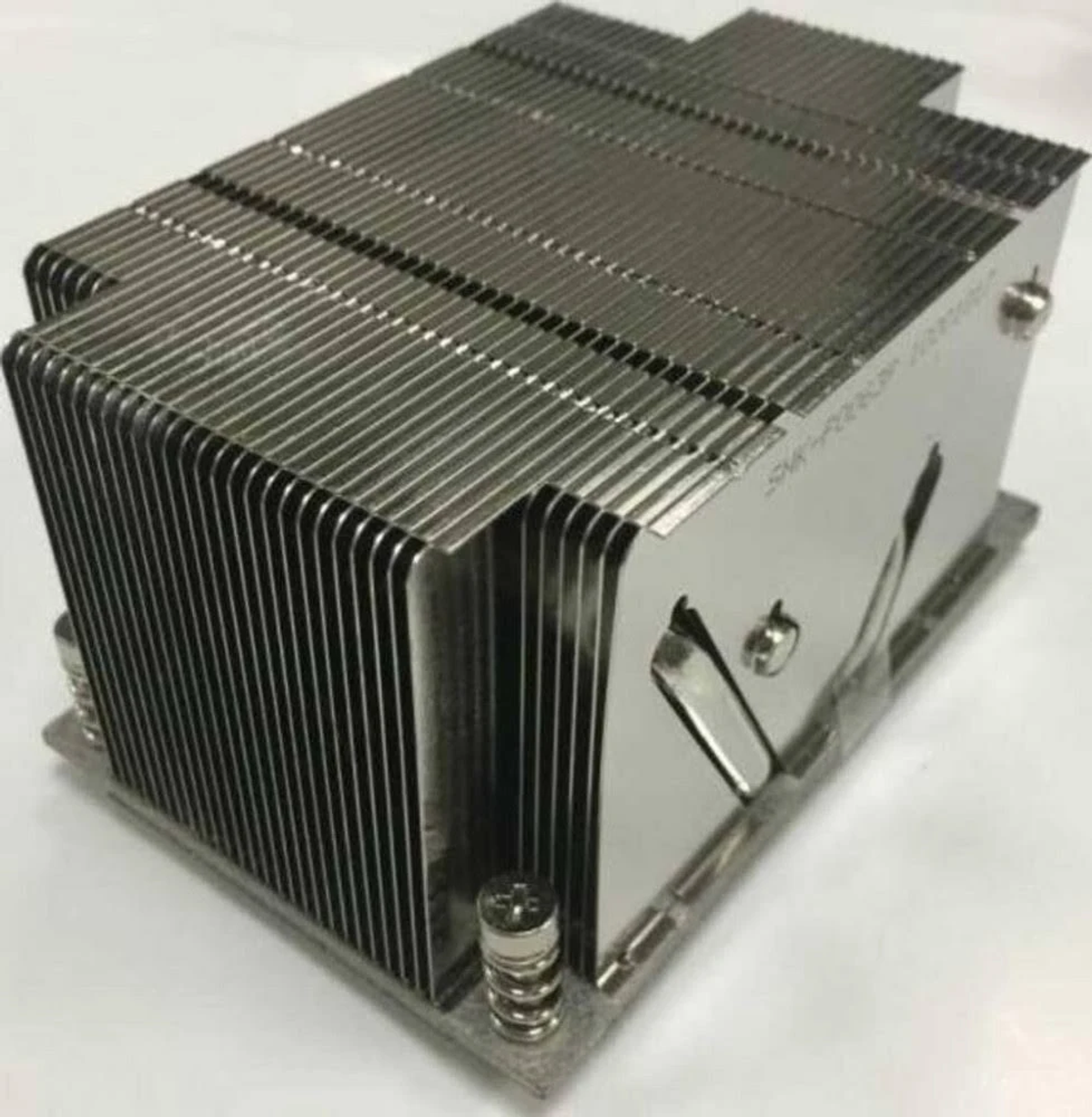 Srebrny radiator do komputera. Ma wiele żeber i prostokątny kształt. Szare tło.