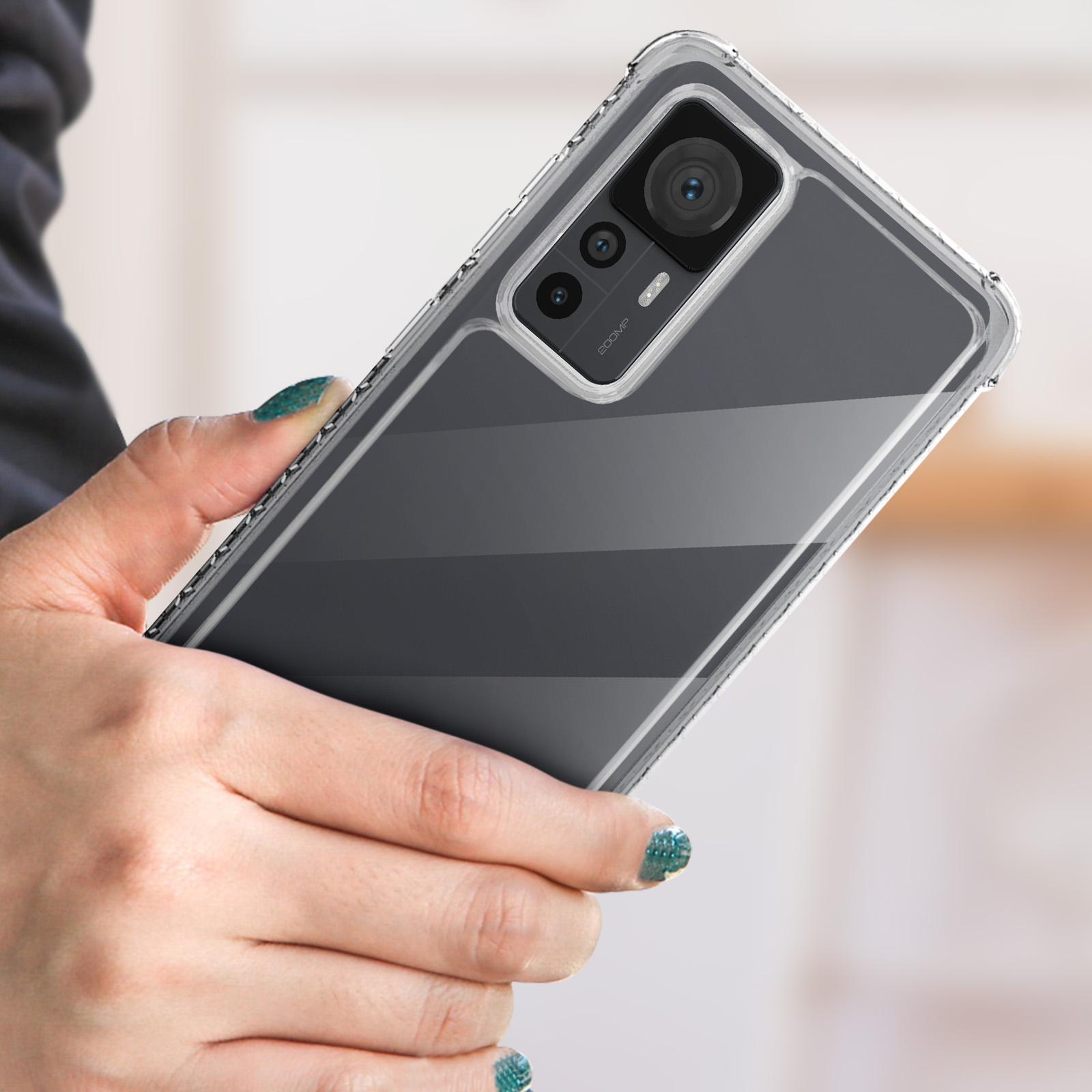 Persoon die een transparante telefoonhoes vasthoudt. De telefoonhoes zit op een telefoon. Groene nagellak op de hand.