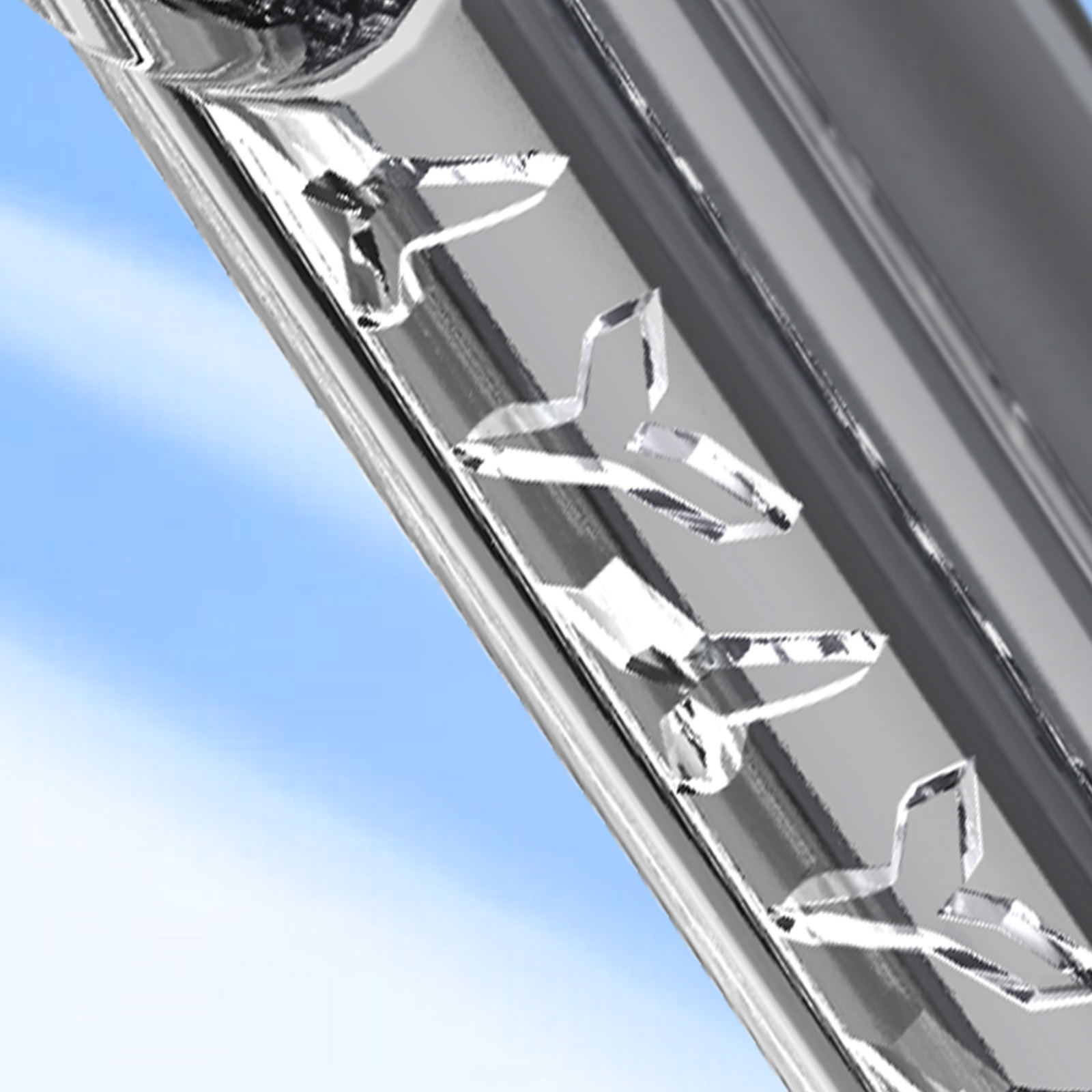 Gros plan d'une surface métallique brillante avec des motifs en forme d'avion, contre un ciel bleu.