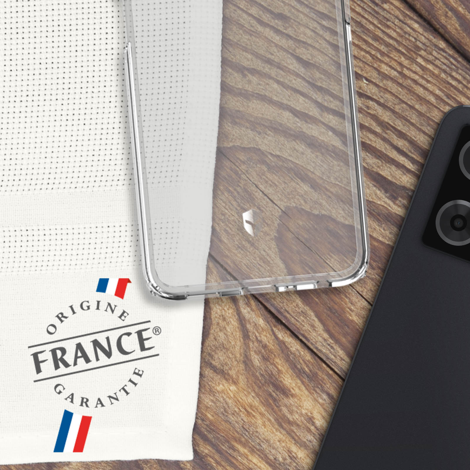 Coque de téléphone transparente avec tissu blanc et téléphone noir. Fond en bois et logo de la France.