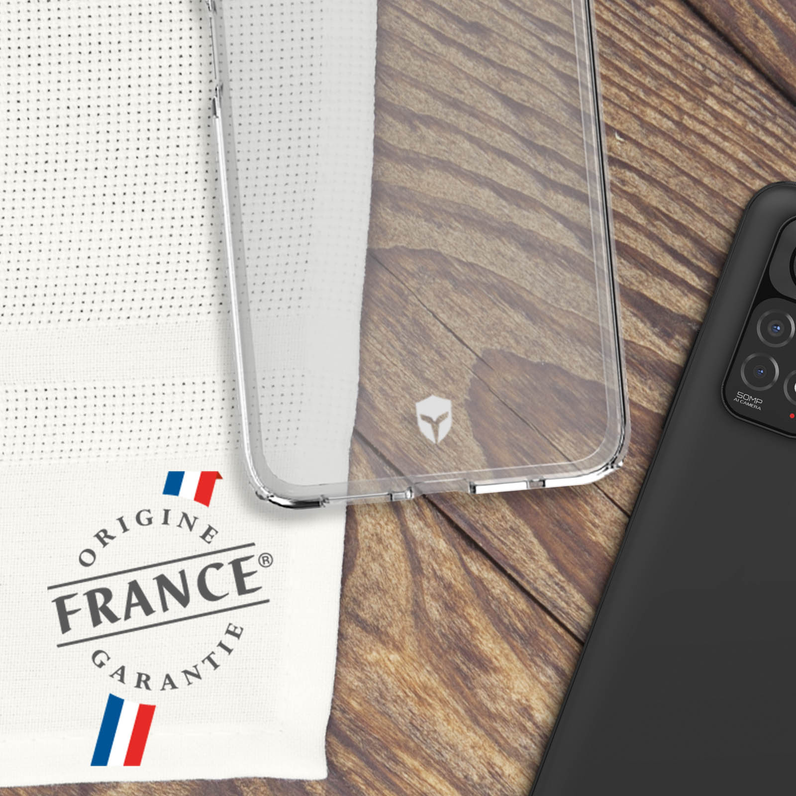 Telefoon en doorzichtige hoes, met een doek met Origine France Garantie.