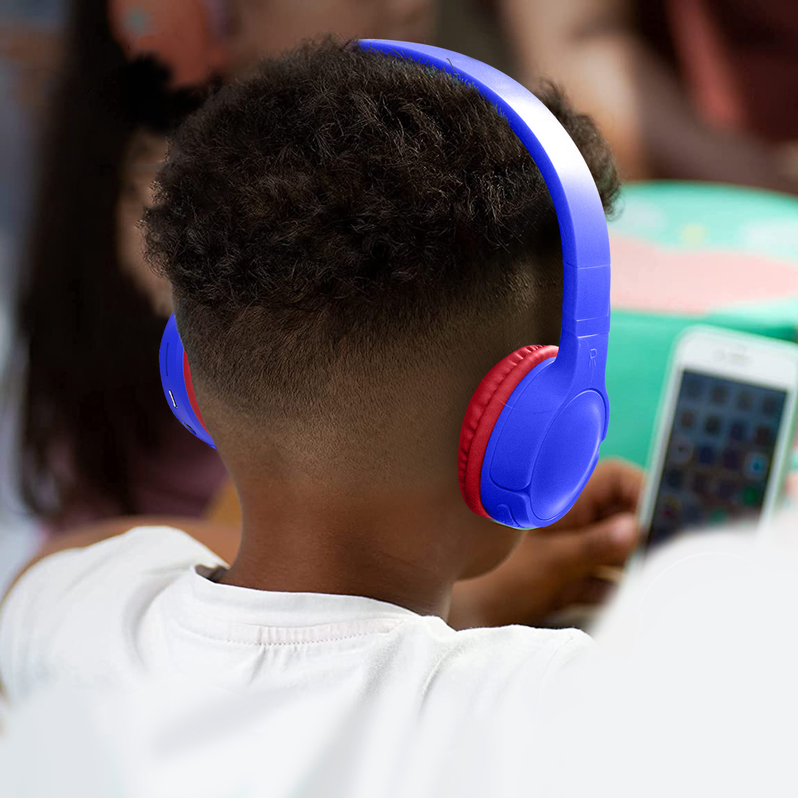 Un garçon portant un casque bleu avec des oreillettes rouges, seul son dos est visible.