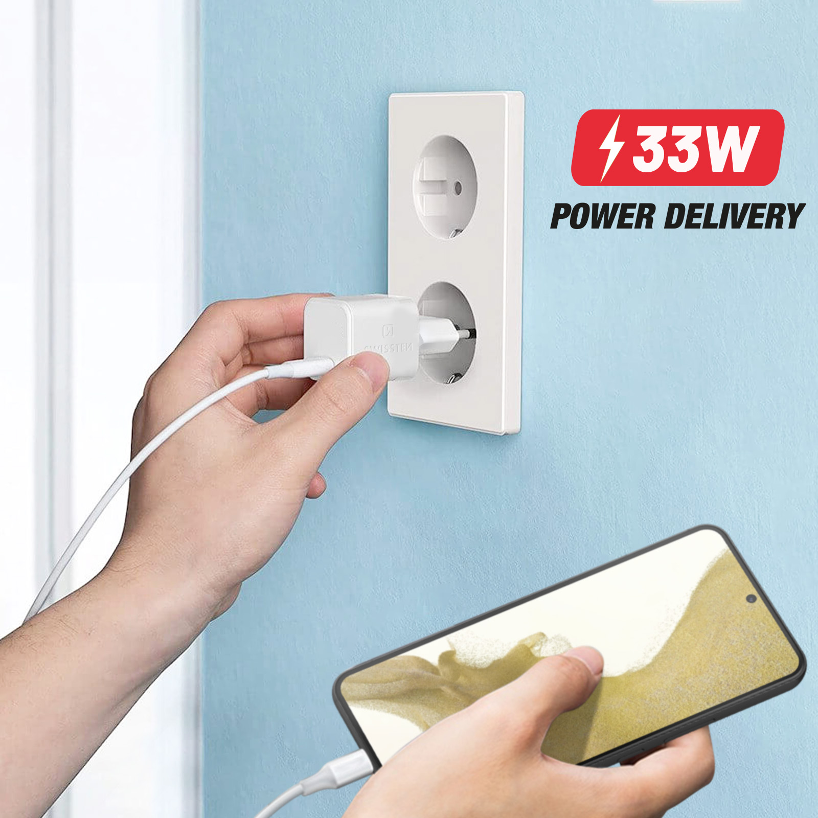 Ręka podłącza białą ładowarkę do gniazdka. Telefon się ładuje.