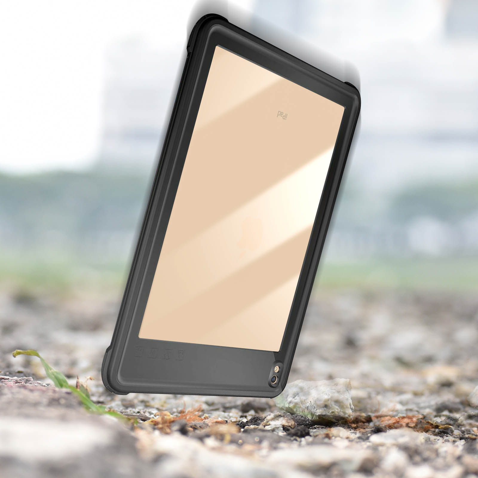 Tablet fällt, schwarzes Gehäuse. Beigefarbener Bildschirm. Draußen, verschwommener Hintergrund, Steine.