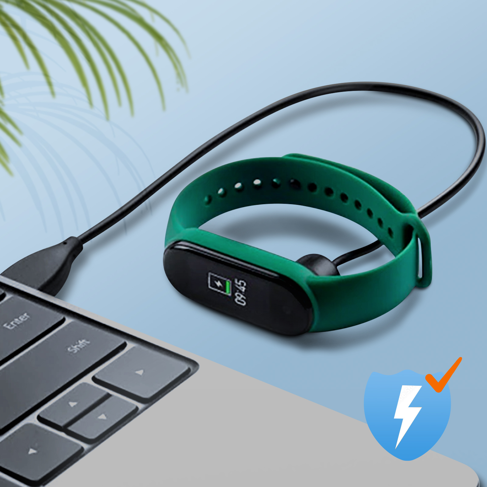 Tracker fitness verde in carica. Cavo nero, tastiera del laptop e simbolo di ricarica.