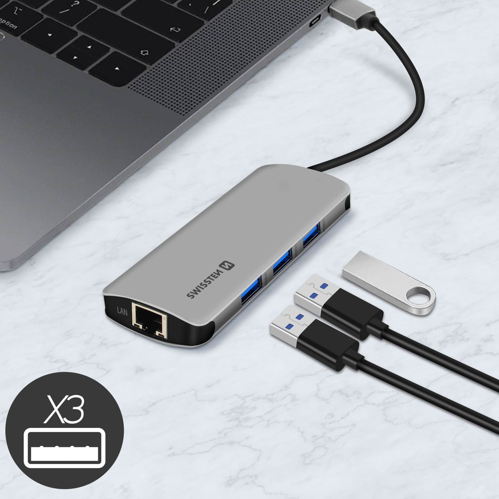 Laptop mit silbernem Hub, Kabeln und USB-Stick auf Marmoroberfläche, neben einem Laptop.