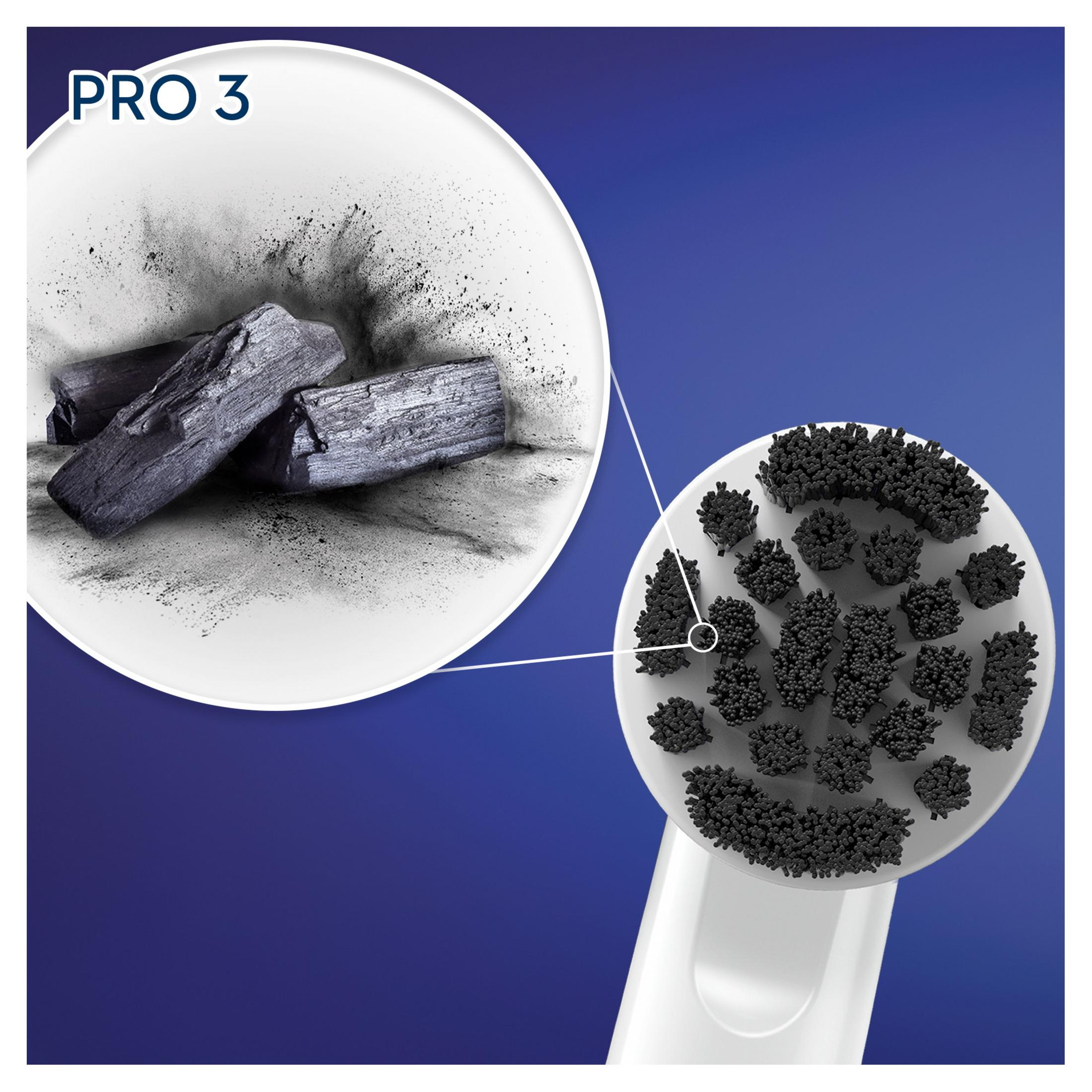 Primer plano de un cabezal de cepillo de dientes con carbón y trozos de carbón.