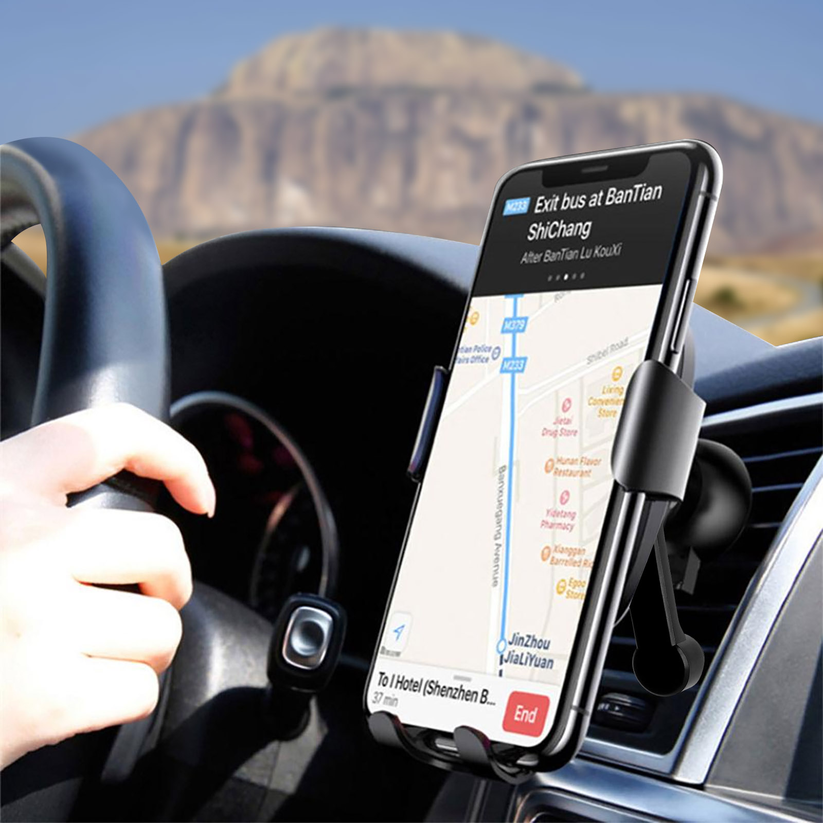 Ein Telefon in einer Autohalterung, das eine Karte mit Wegbeschreibungen zeigt, neben einer Hand am Lenkrad.