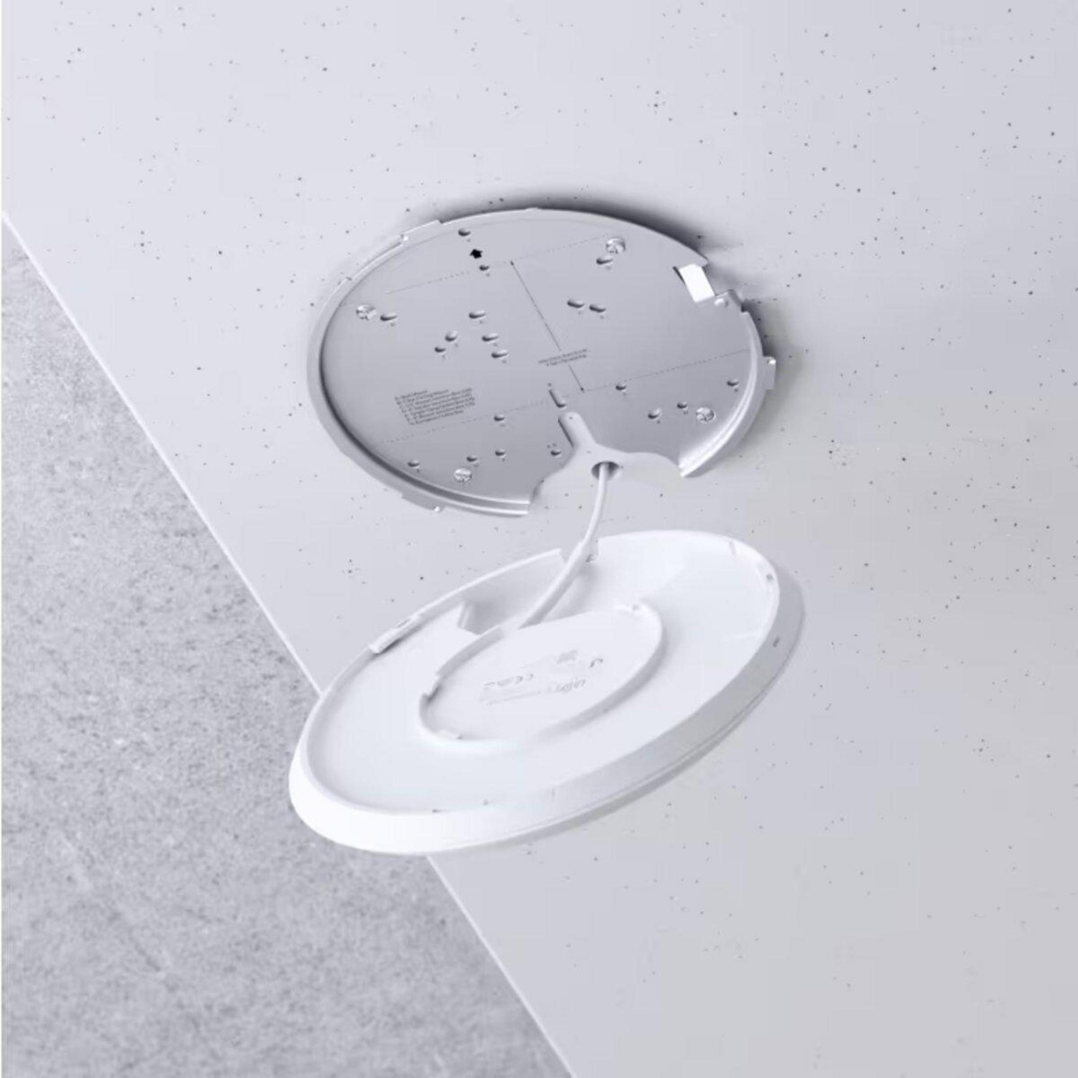 Instalacja oświetlenia sufitowego. Okrągła oprawa oświetleniowa z widocznym przewodem.