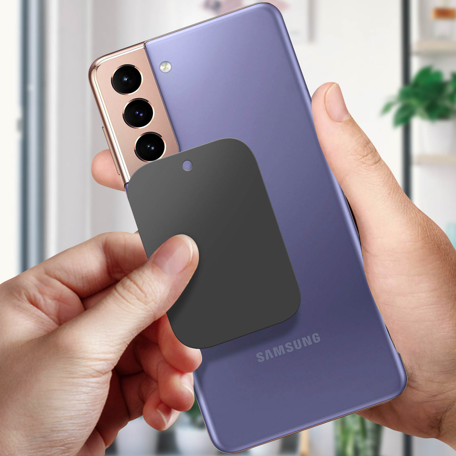 Mani che tengono un telefono Samsung viola con una piastra magnetica nera sul retro.