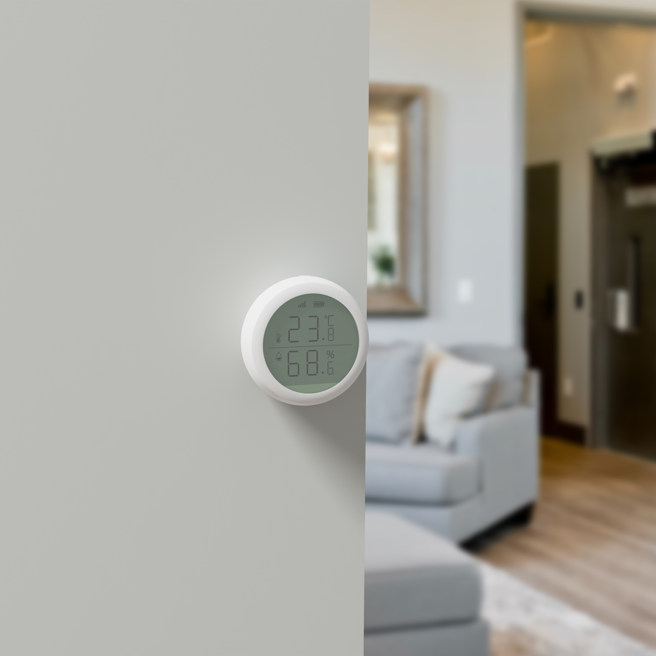 Ein weißes, rundes Smart-Home-Gerät an einer grauen Wand, das Temperatur- und Feuchtigkeitswerte anzeigt.